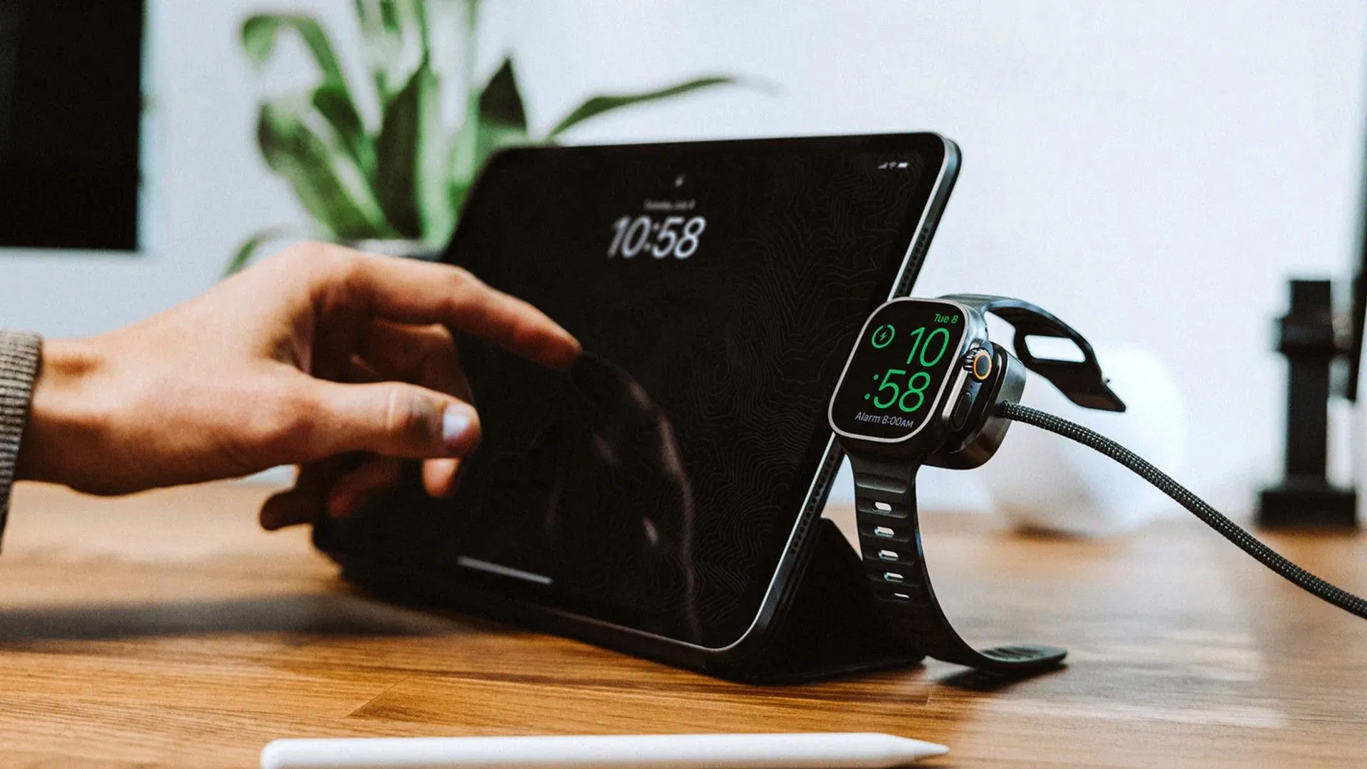 Cáp sạc đa năng Nomad Universal Cable for Apple Watch đang được sử dụng để sạc Apple Watch và các thiết bị USB-C khác.