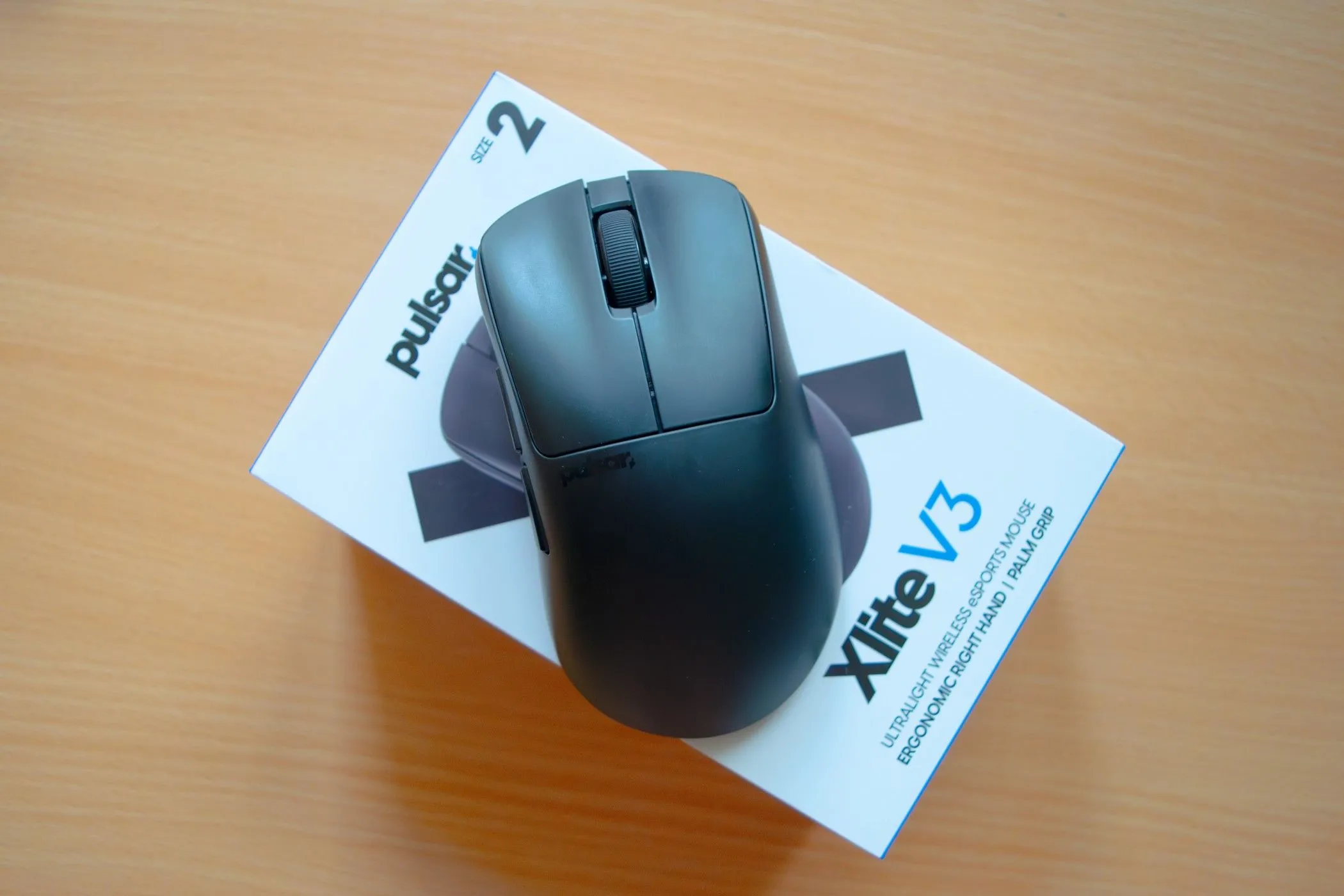 Chuột gaming siêu nhẹ Pulsar Xlite V3 màu trắng đen nằm trên hộp đựng, minh họa cho một trong những loại chuột gaming cao cấp.