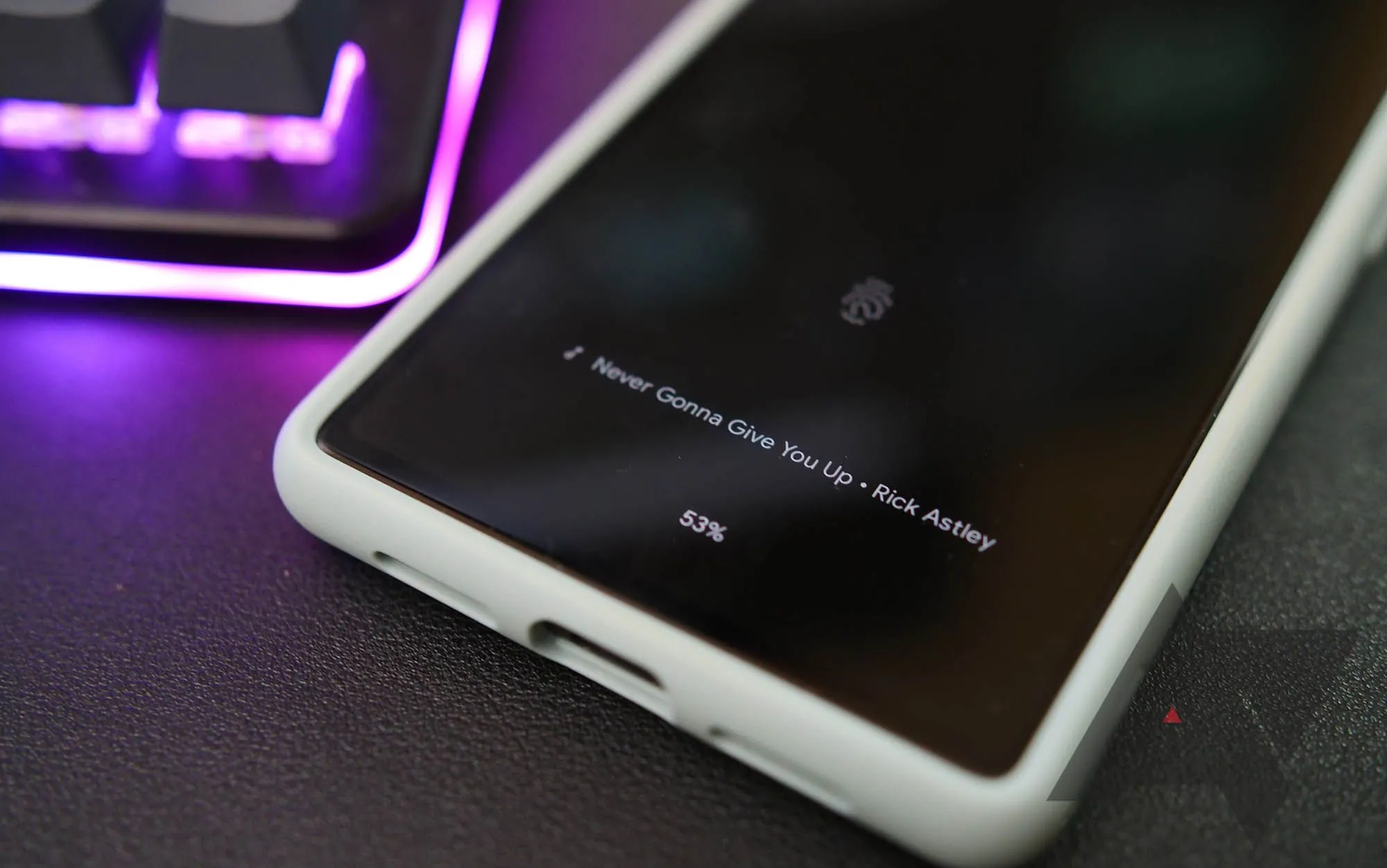 Điện thoại Google Pixel hiển thị tính năng Now Playing trên màn hình khóa cạnh bàn phím có đèn nền tím