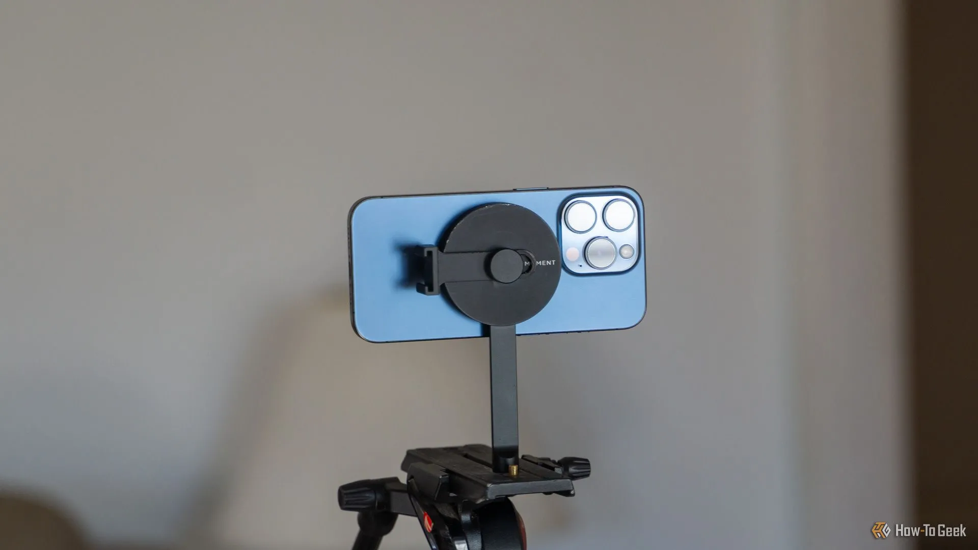 Điện thoại iPhone 15 Pro gắn ngang trên giá đỡ chân máy Moment MagSafe để quay video ổn định
