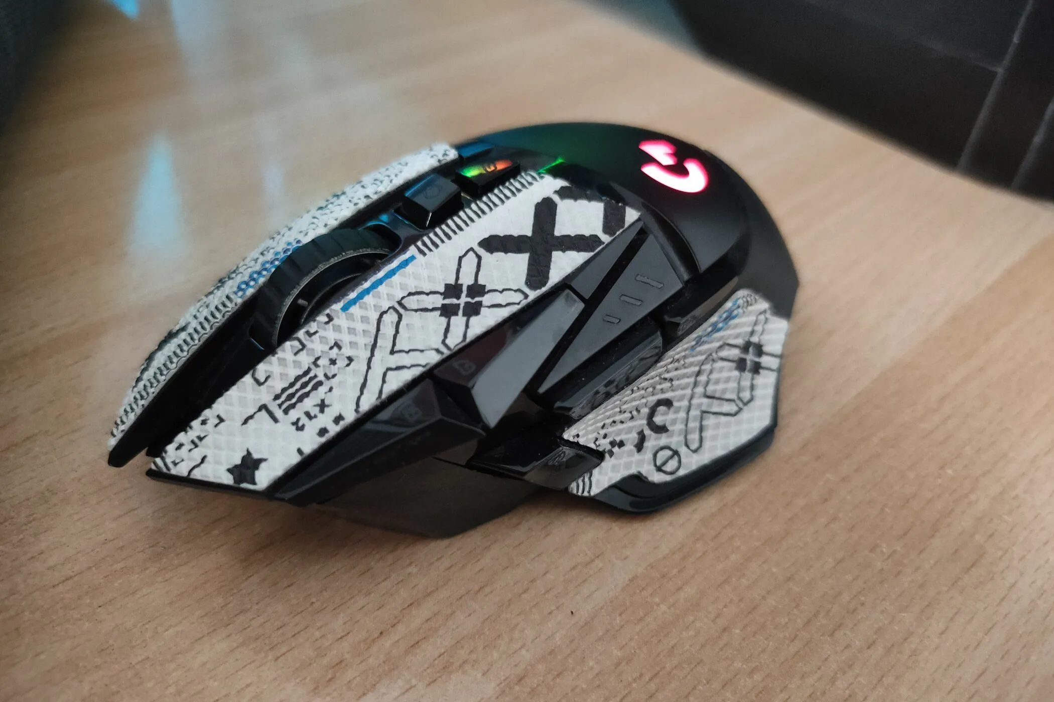 Góc nhìn cạnh của chuột gaming không dây Logitech G502 Lightspeed trên bàn gỗ.