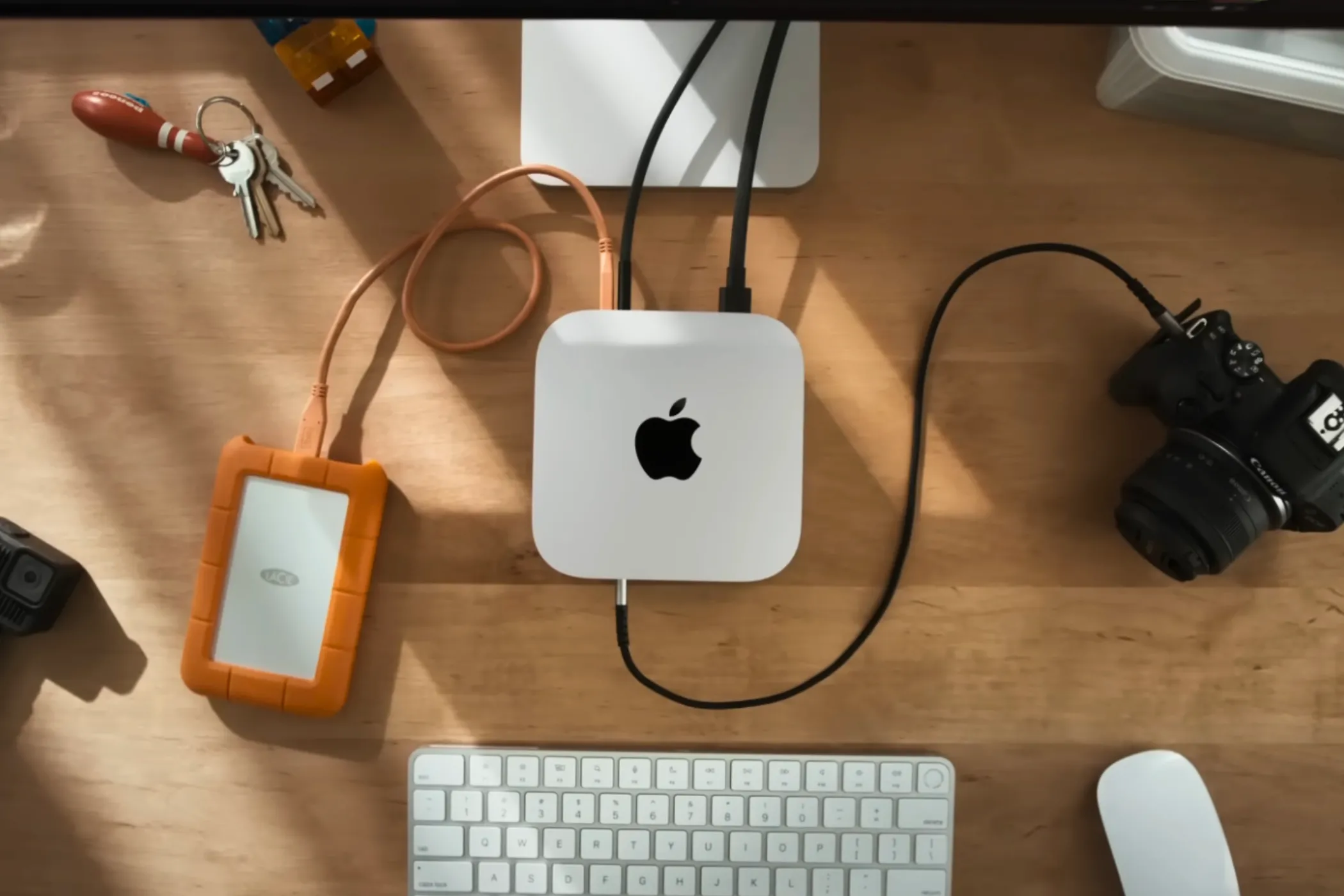Góc nhìn từ trên xuống của Mac Mini M4 trên bàn làm việc, xung quanh là các phụ kiện.