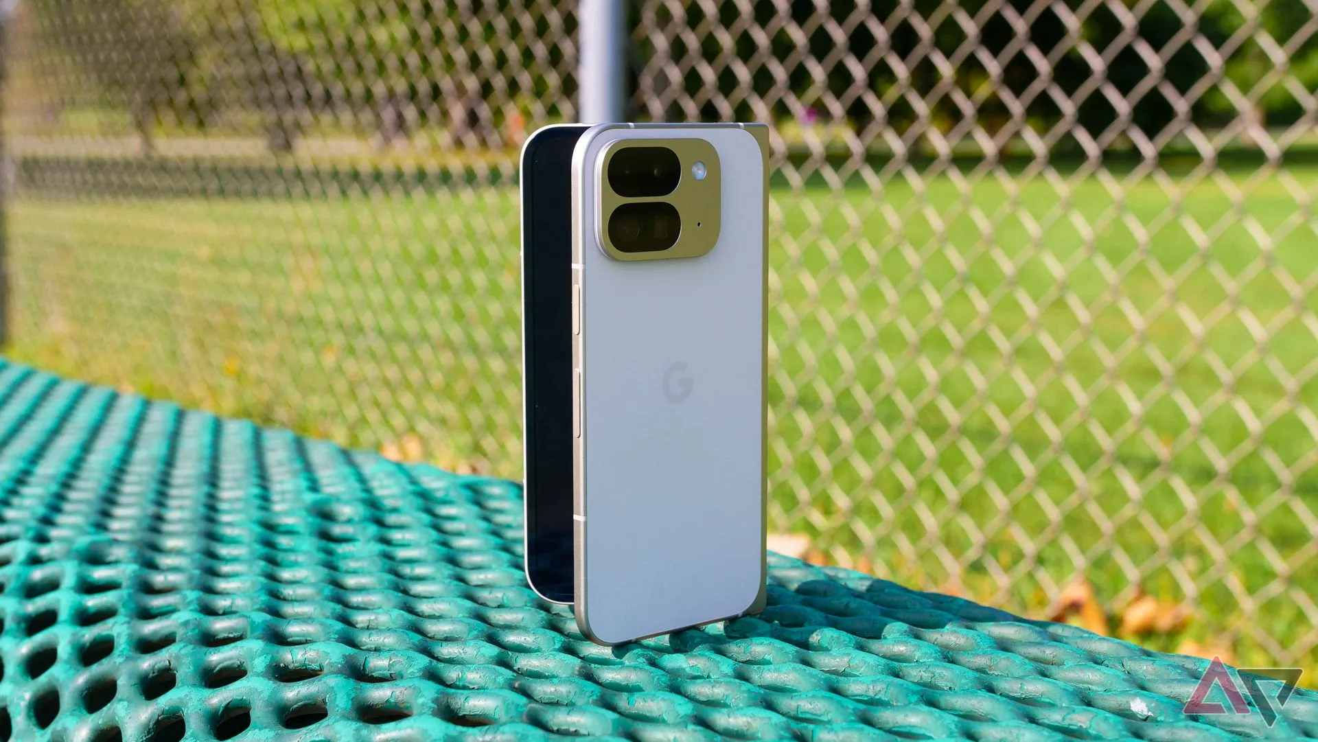 Google Pixel 9 Pro Fold màu xanh lá cây đặt trên ghế công viên