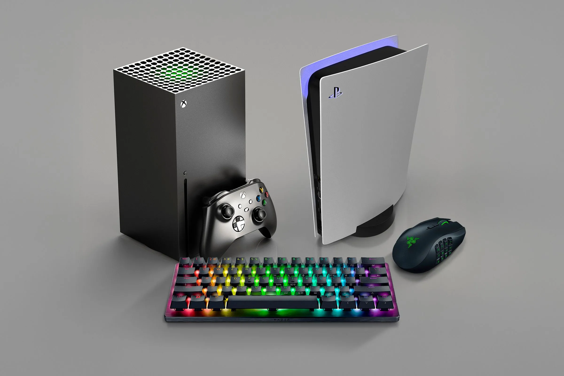 Hình ảnh máy chơi game Xbox và PlayStation cùng chuột và bàn phím, đại diện cho các nền tảng có hệ thống thành tích gây tranh cãi.