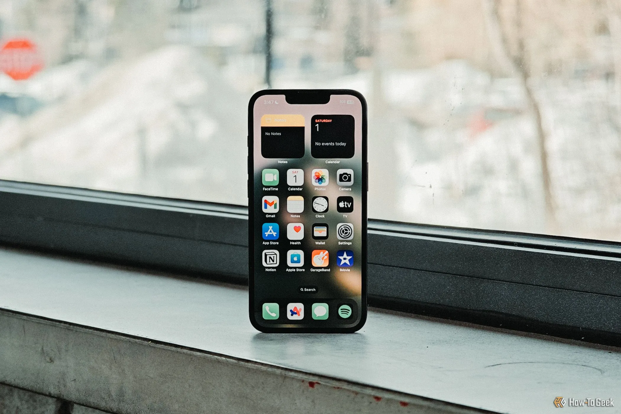 Màn hình chính iPhone 16e hiển thị các ứng dụng, đặt trước khung cửa sổ tràn đầy ánh sáng