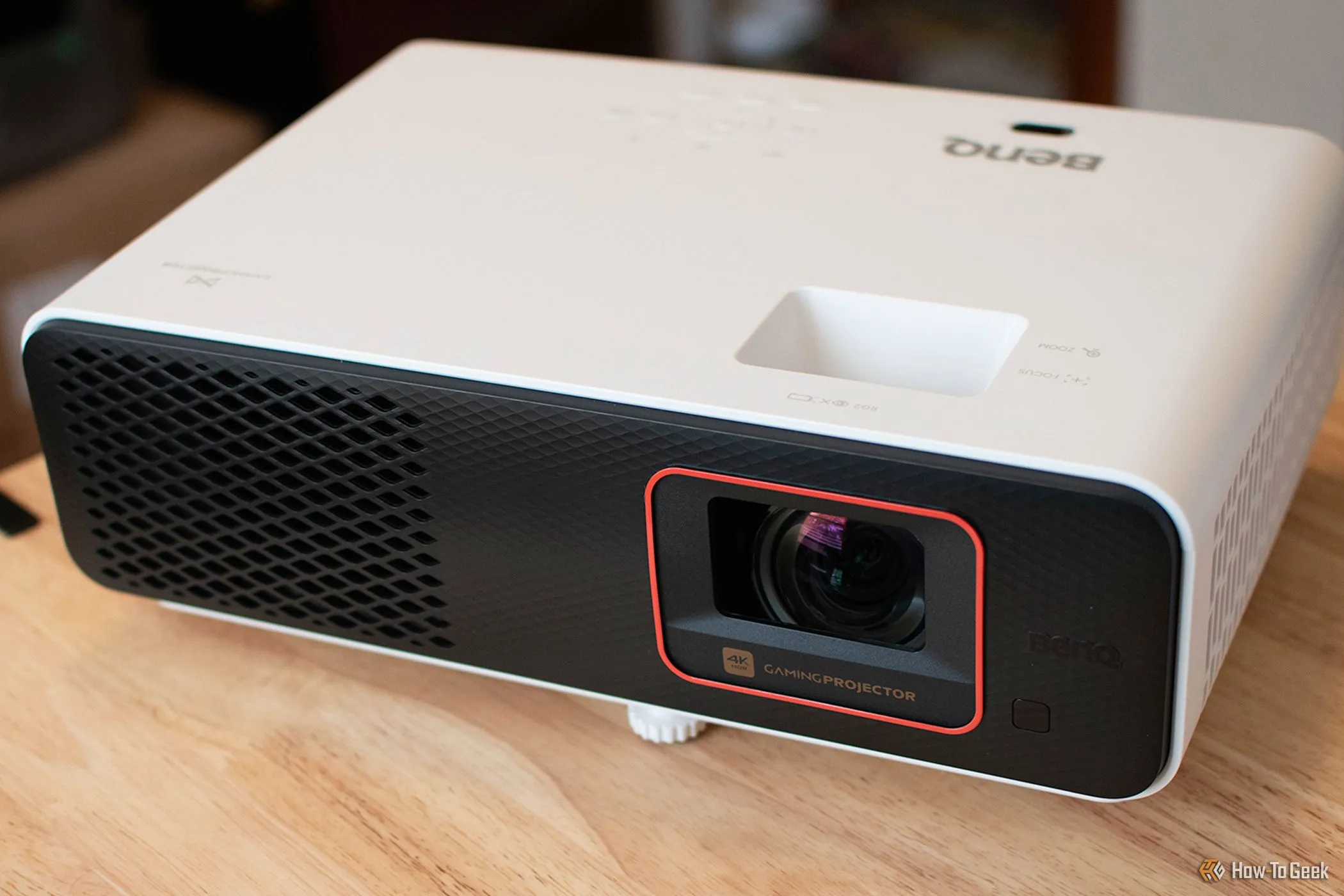Máy chiếu BenQ X500i short-throw màu trắng đặt trên bàn, hiển thị hình ảnh sắc nét
