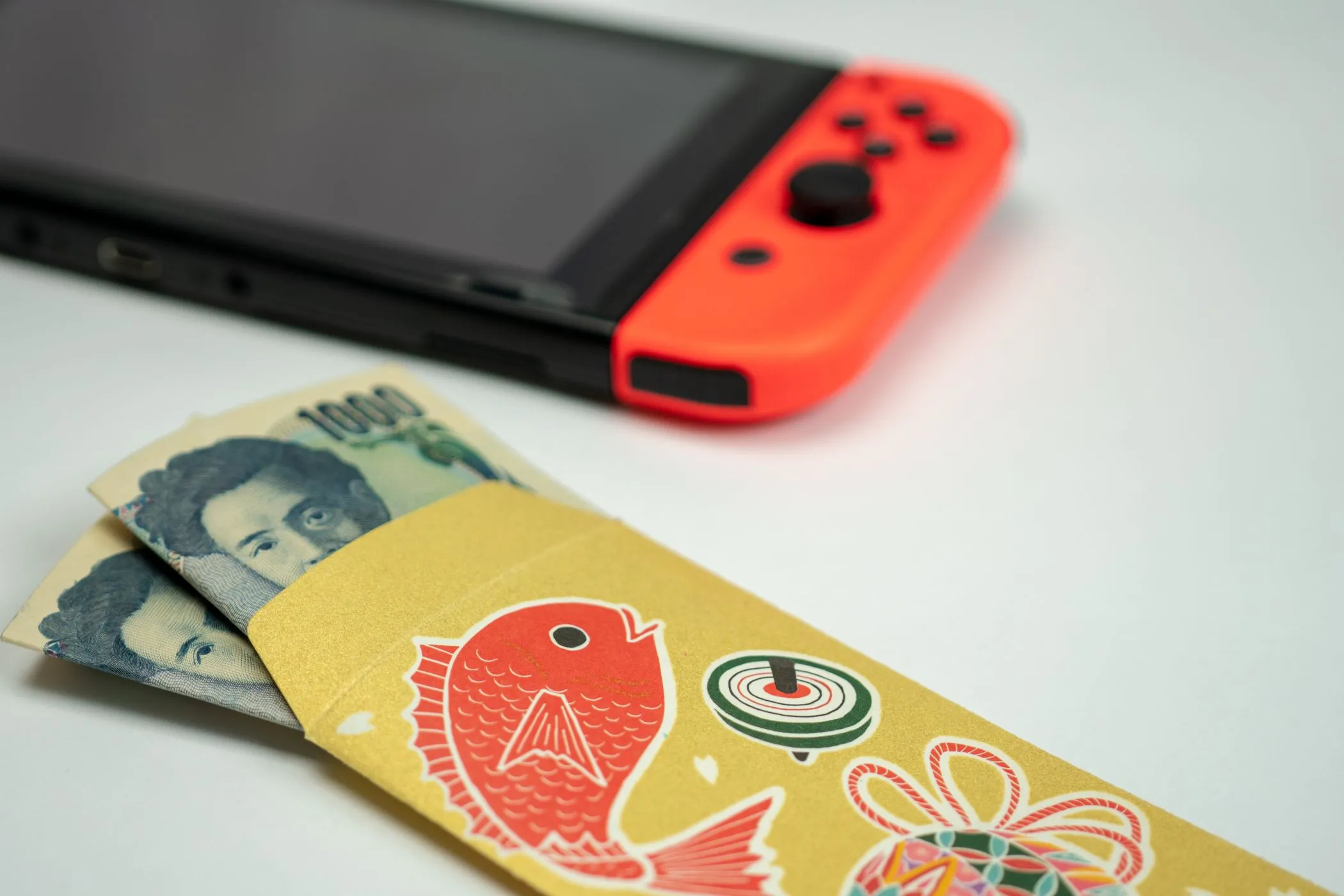 Máy Nintendo Switch và tiền mặt, tượng trưng cho khoản đầu tư vào dịch vụ online và game
