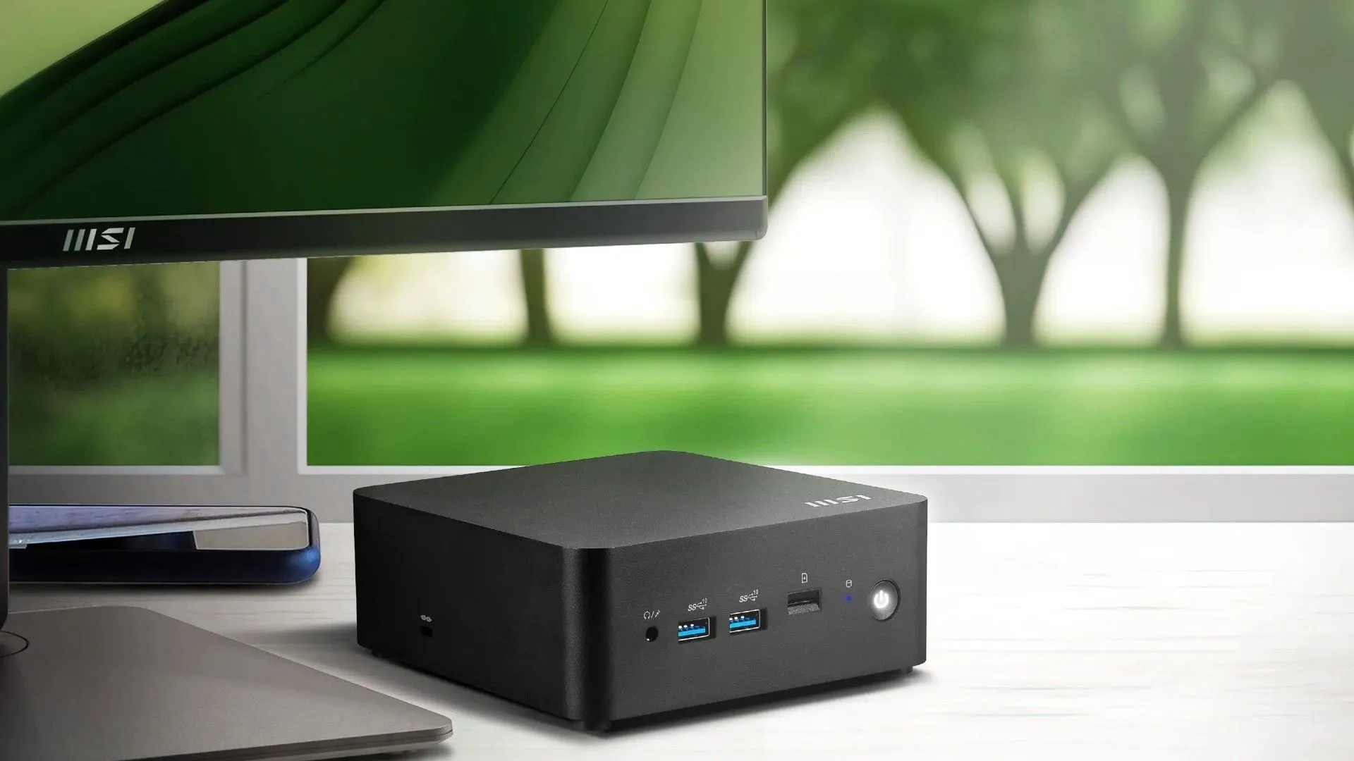 Máy tính mini MSI Cubi NUC AI Series đặt cạnh màn hình