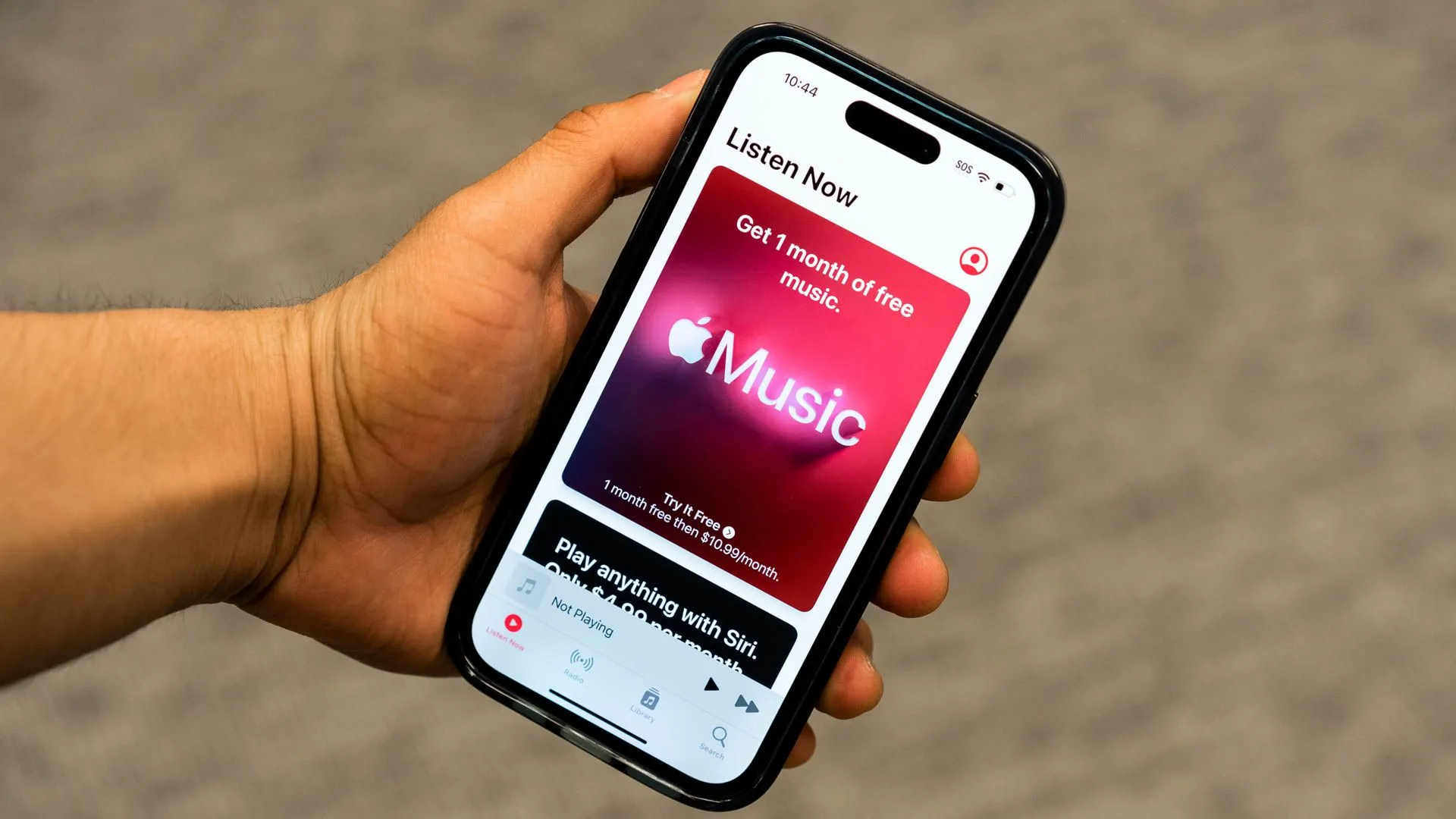 Một bàn tay cầm iPhone hiển thị ứng dụng Apple Music