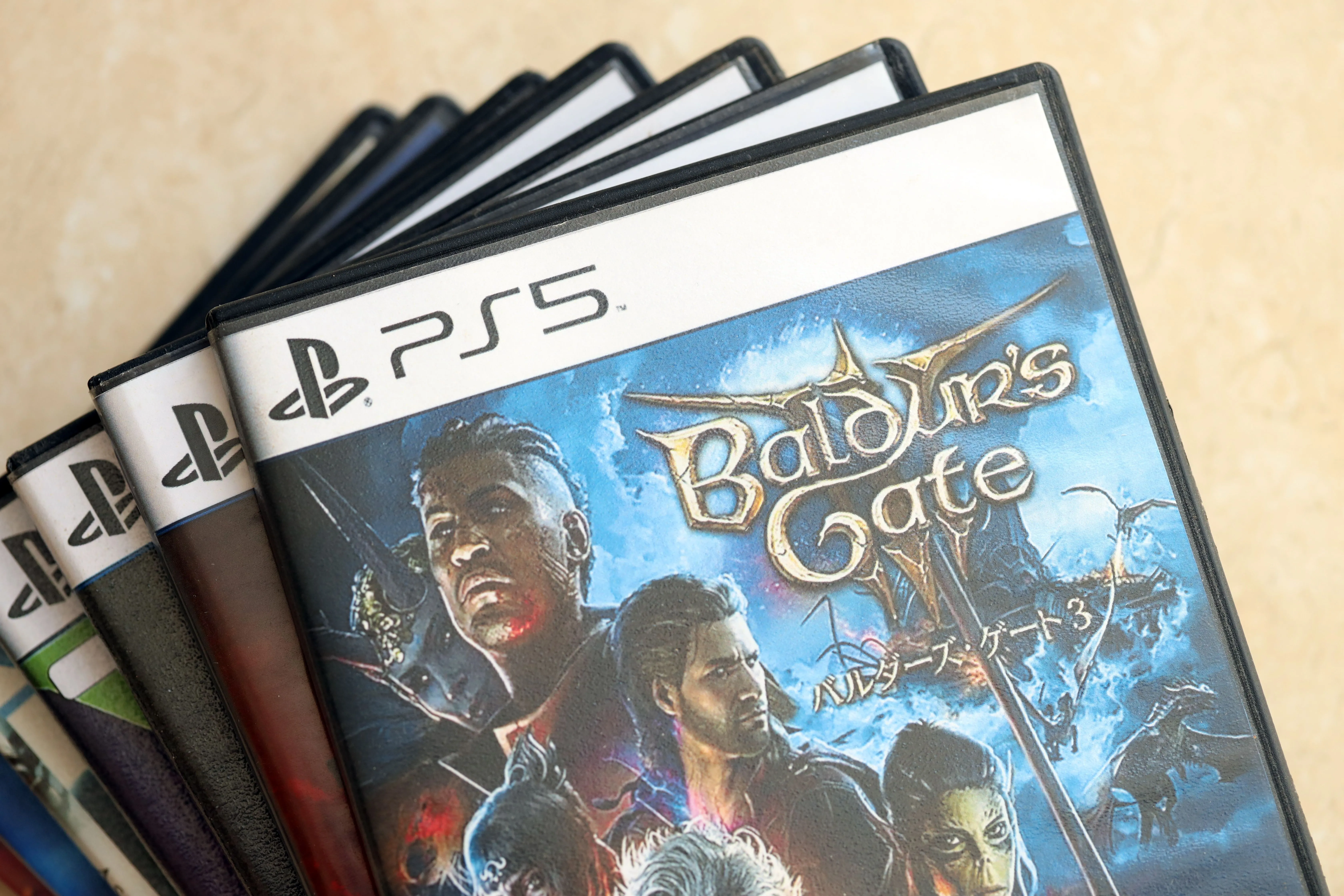 Một chồng đĩa game PS5 với đĩa Baldur's Gate 3 ở trên cùng, thể hiện giá trị của bộ sưu tập game vật lý.
