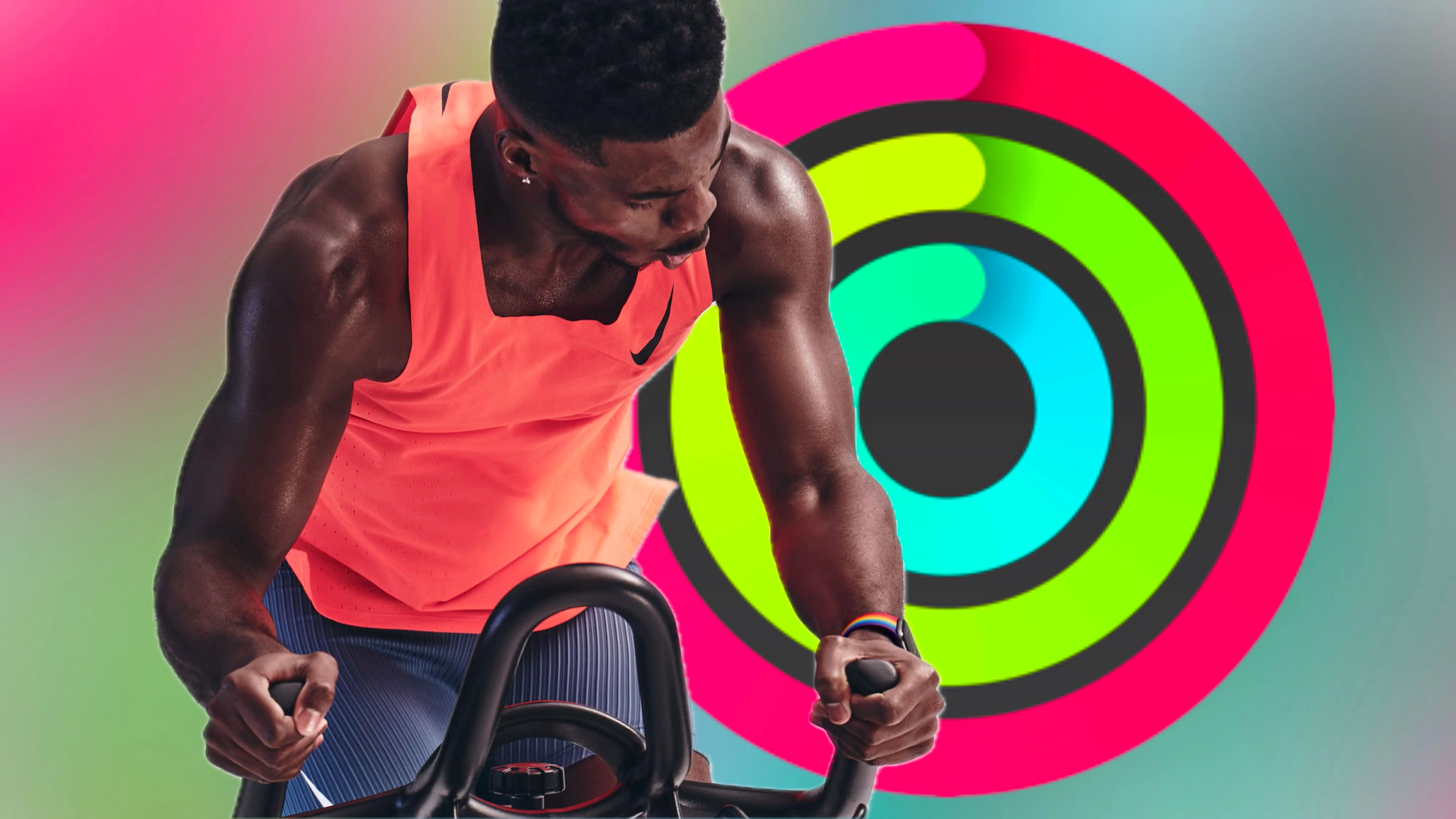 Một huấn luyện viên Apple Fitness+ đang tập luyện trước bức ảnh Activity Rings đã hoàn thành, với nền màu sắc tươi sáng