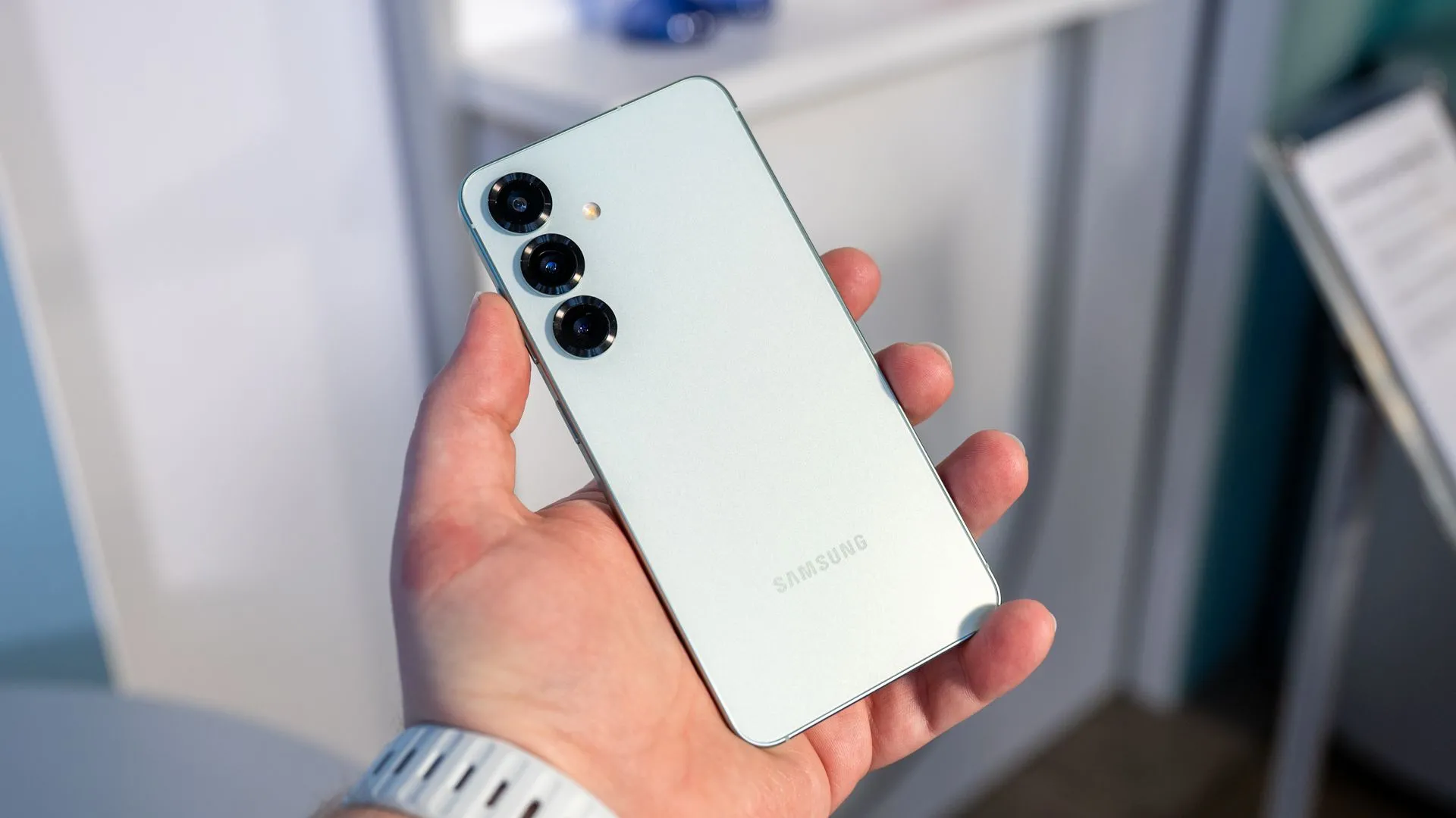 Một người cầm Galaxy S25, nhìn vào cụm camera sau của thiết bị.