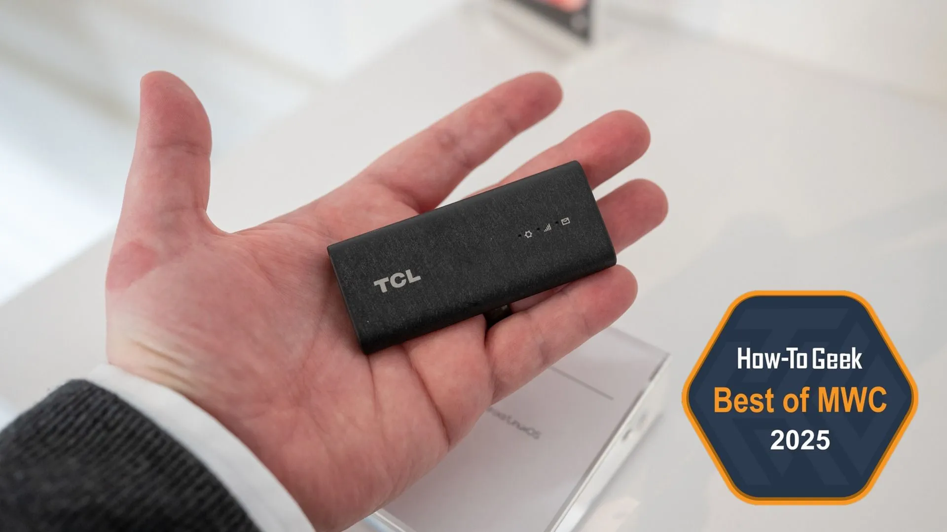 Một người đang cầm thiết bị USB Dongle 5G RedCap TCL LINKPORT IK511.