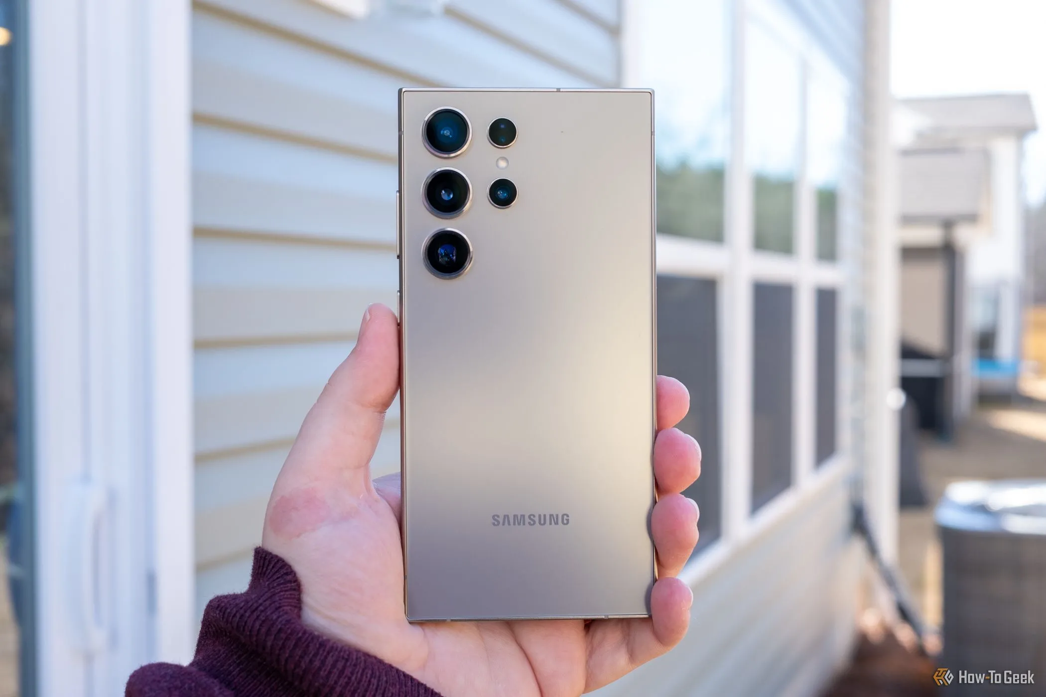 Người dùng đang cầm điện thoại Samsung Galaxy S24 Ultra màu xám