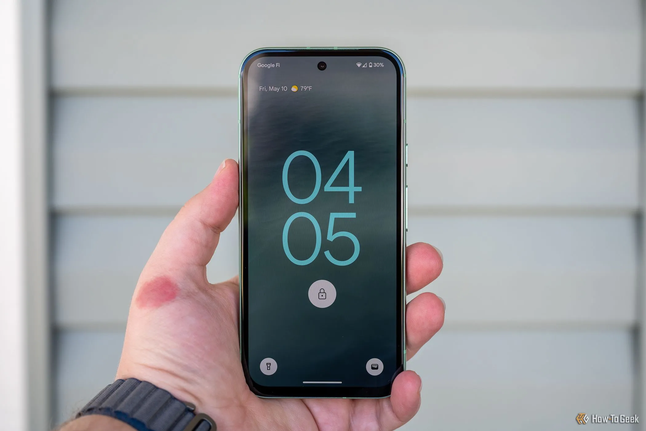 Người dùng đang tương tác với màn hình khóa của Google Pixel 8a