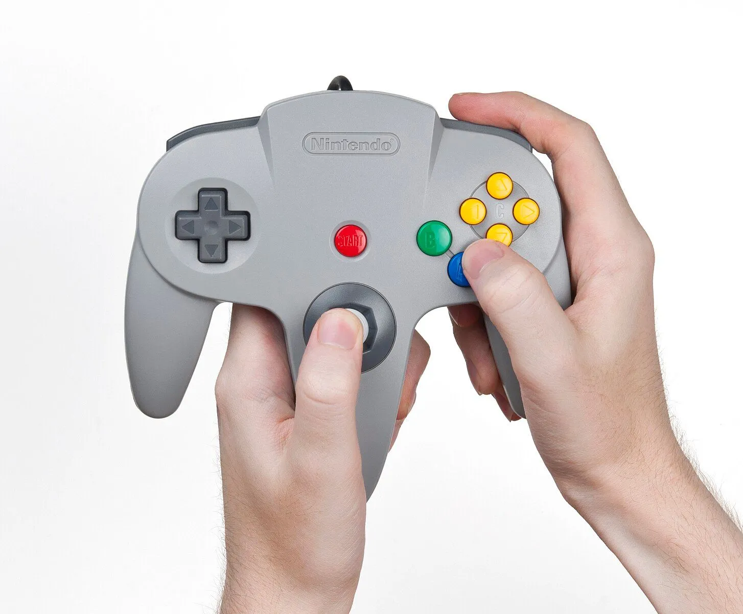Tay cầm Nintendo 64 (N64) với thiết kế ba chạc đặc trưng được cầm trên tay.