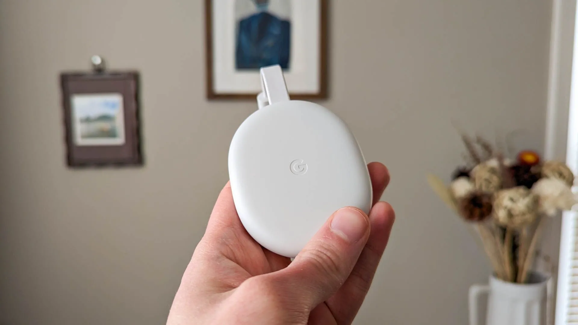 Thiết bị Chromecast màu trắng được cắm vào cổng HDMI của một chiếc TV.