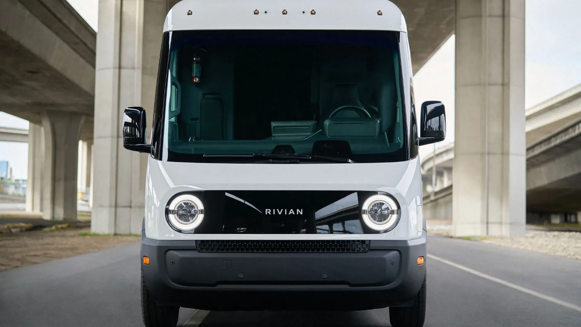 Xe van điện Rivian màu trắng đang chạy trên đường phố