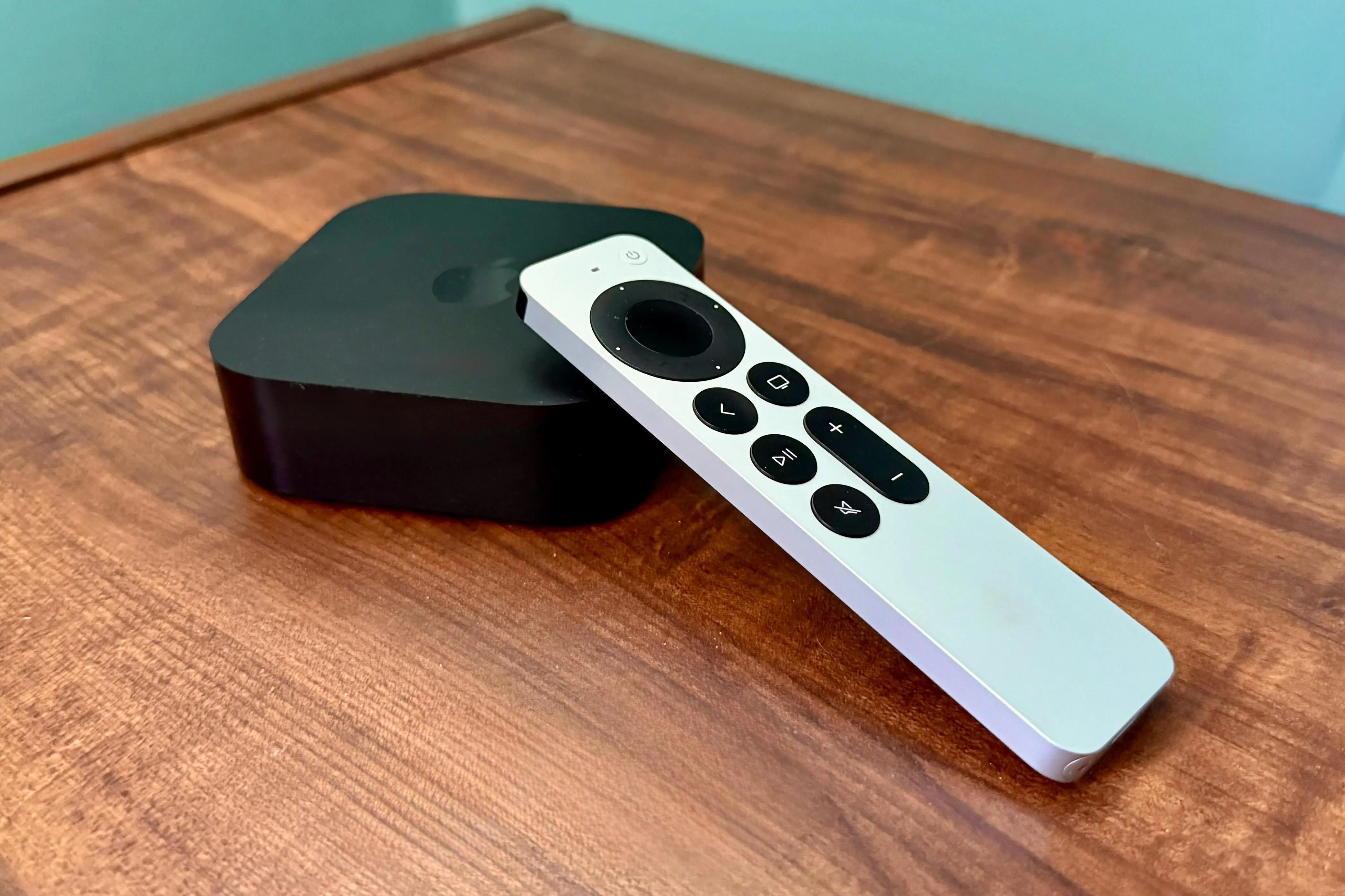 Apple TV 4K cùng điều khiển từ xa đặt trên bàn gỗ, sẵn sàng cho trải nghiệm giải trí tại gia.