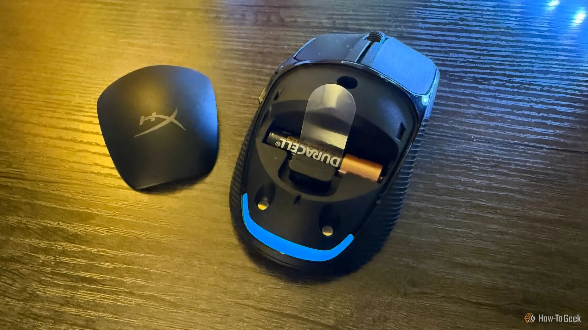 Bên trong chuột HyperX Pulsefire Fuse khi tháo nắp, lộ pin AAA và đầu thu USB 2.4GHz.