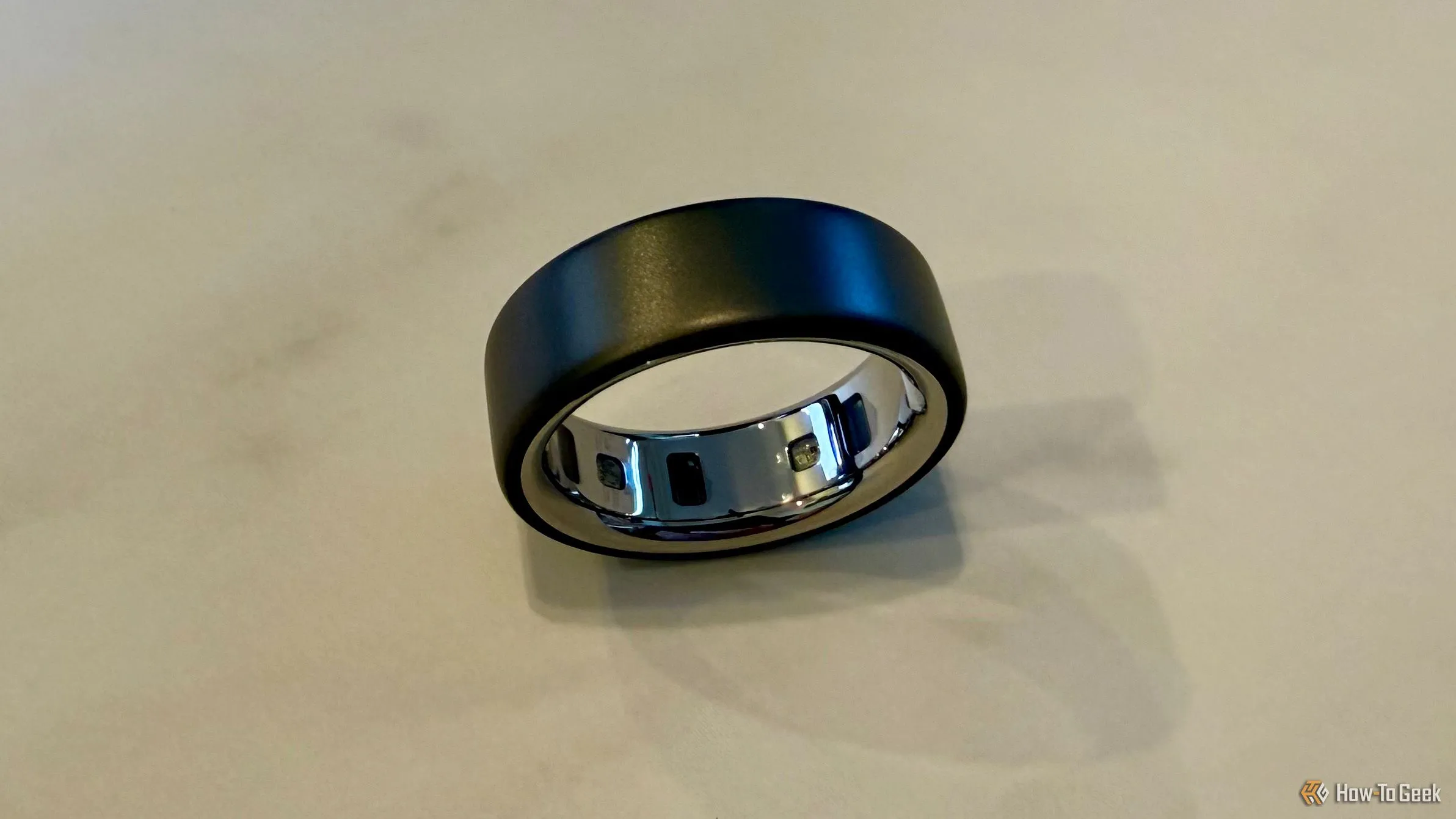 Bên trong Oura Ring 4 đặt trên mặt bàn, hiển thị các cảm biến tiên tiến giúp thu thập dữ liệu sức khỏe chính xác từ ngón tay