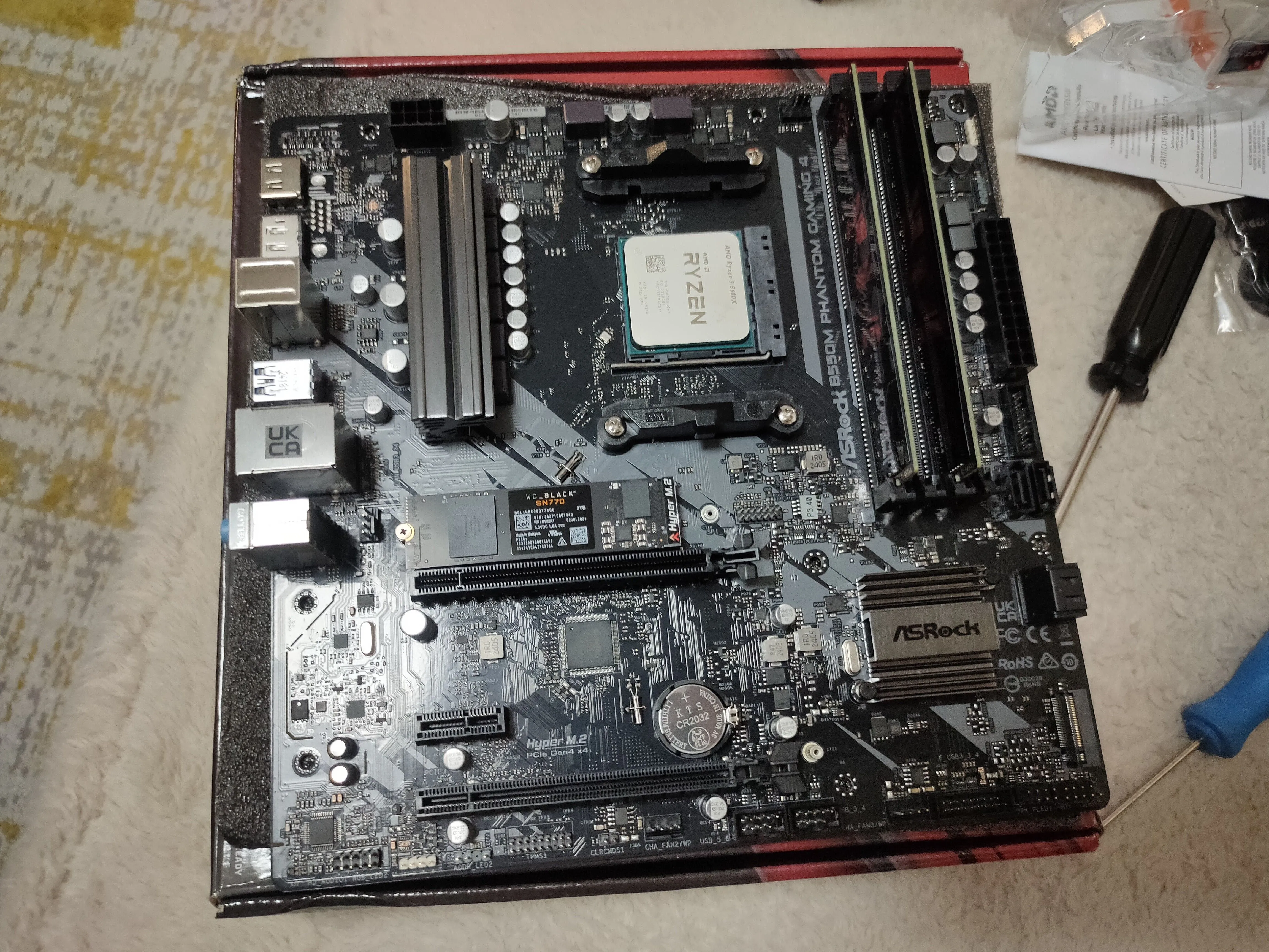Bo mạch chủ được đặt trên hộp, đã lắp CPU và RAM, sẵn sàng kiểm tra trước khi gắn vào vỏ case.