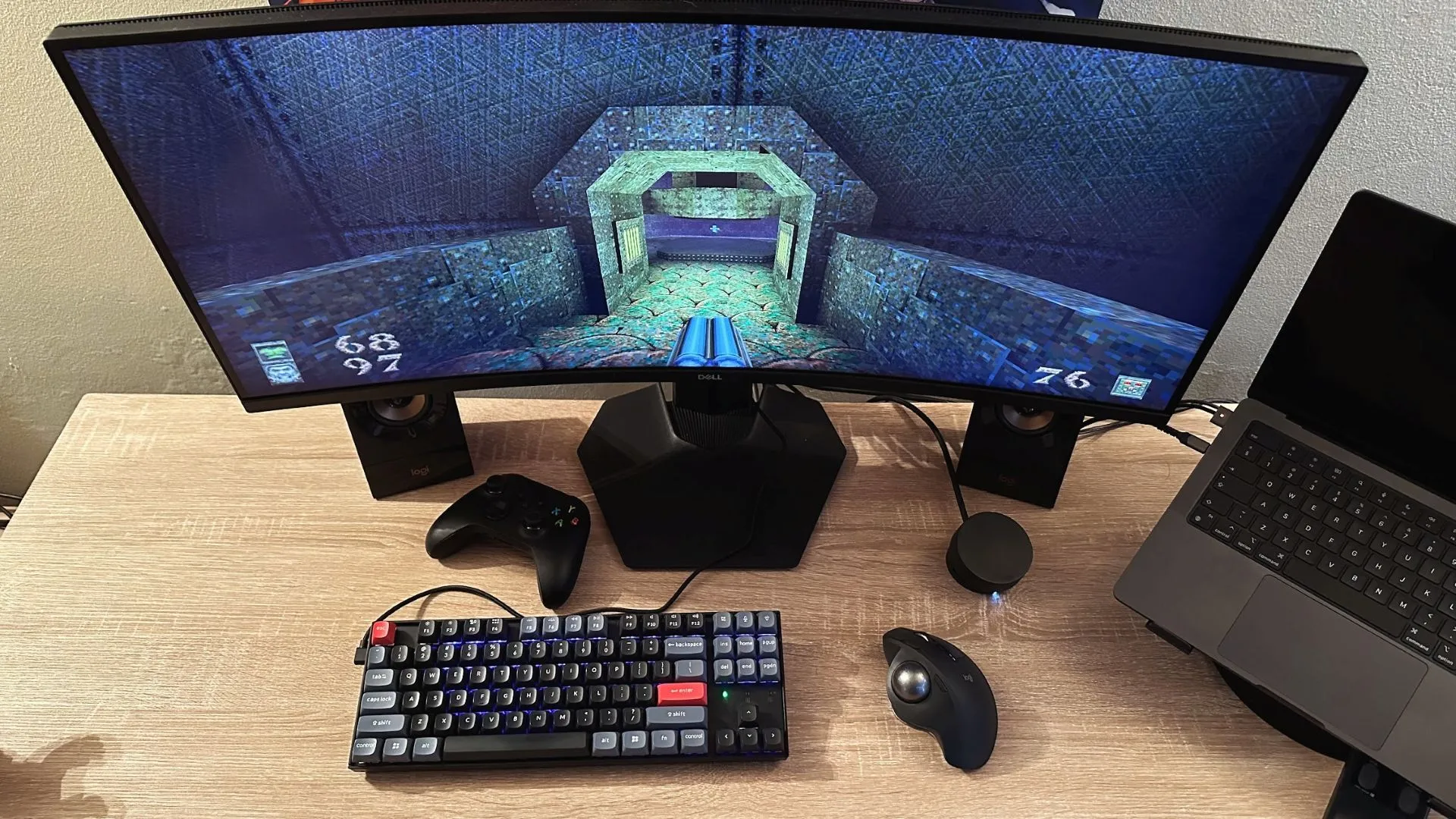 Cận cảnh bàn làm việc với thiết lập chơi game Quake trên màn hình máy tính và chuột bi xoay