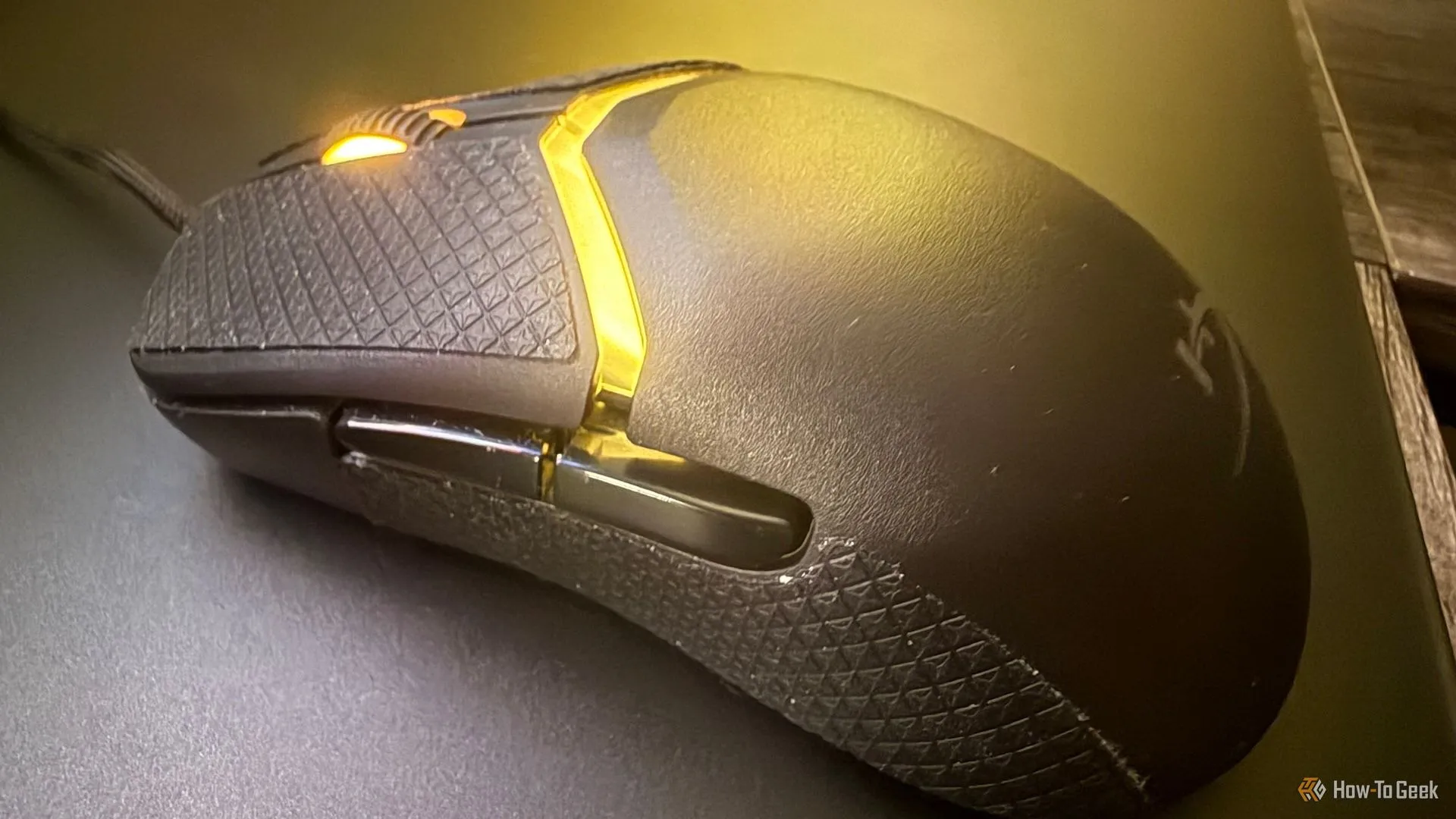 Cận cảnh các nút chuột, băng dính chống trượt và bánh xe cuộn của HyperX Pulsefire Saga.