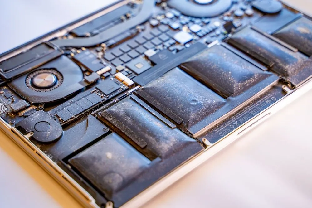 Cận cảnh pin MacBook Pro Retina bị lỗi, cho thấy các linh kiện dán chặt khó sửa chữa.