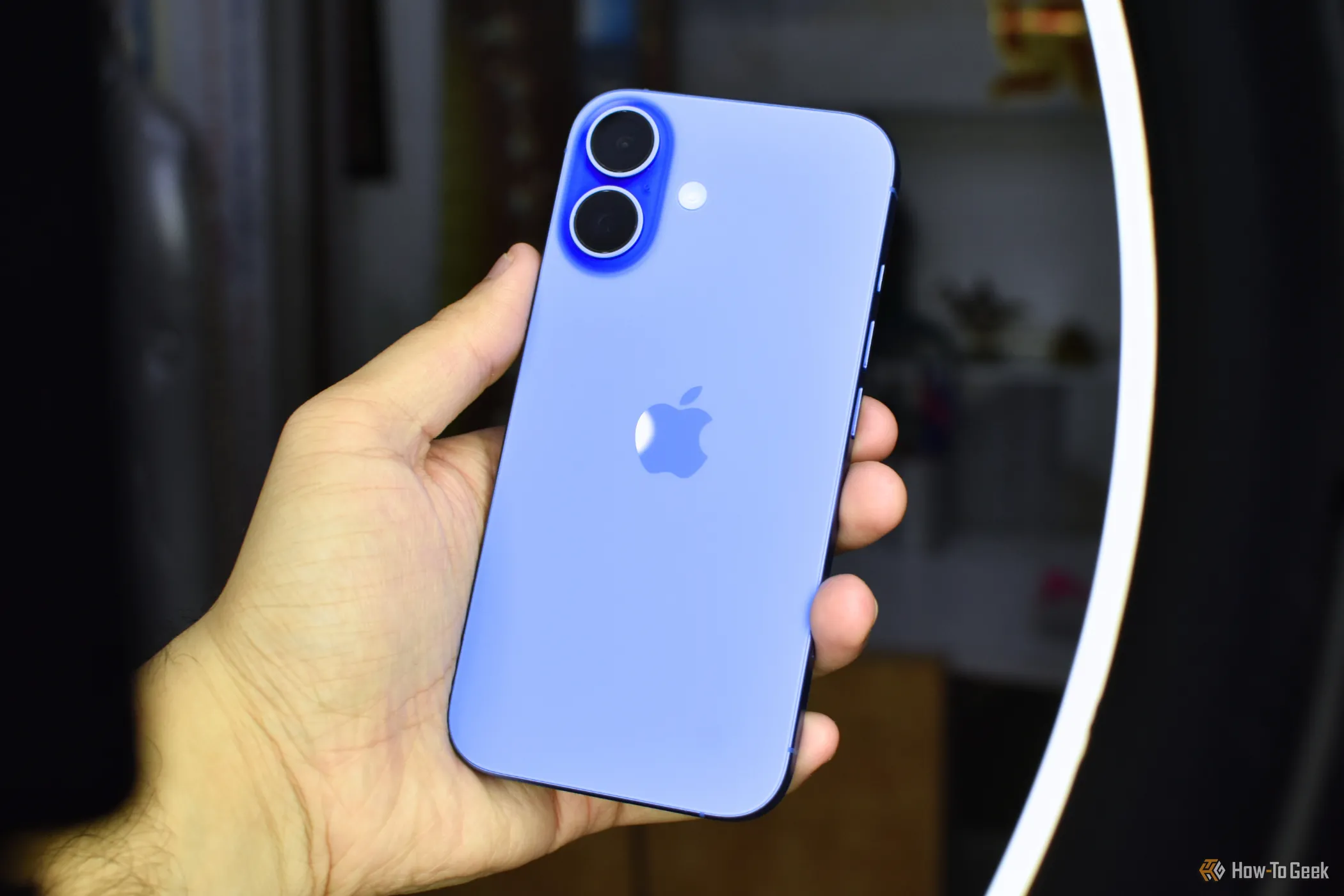 Chiếc iPhone 16 màu Ultramarine được cầm trong tay, tập trung vào thiết kế và màu sắc mới của điện thoại.