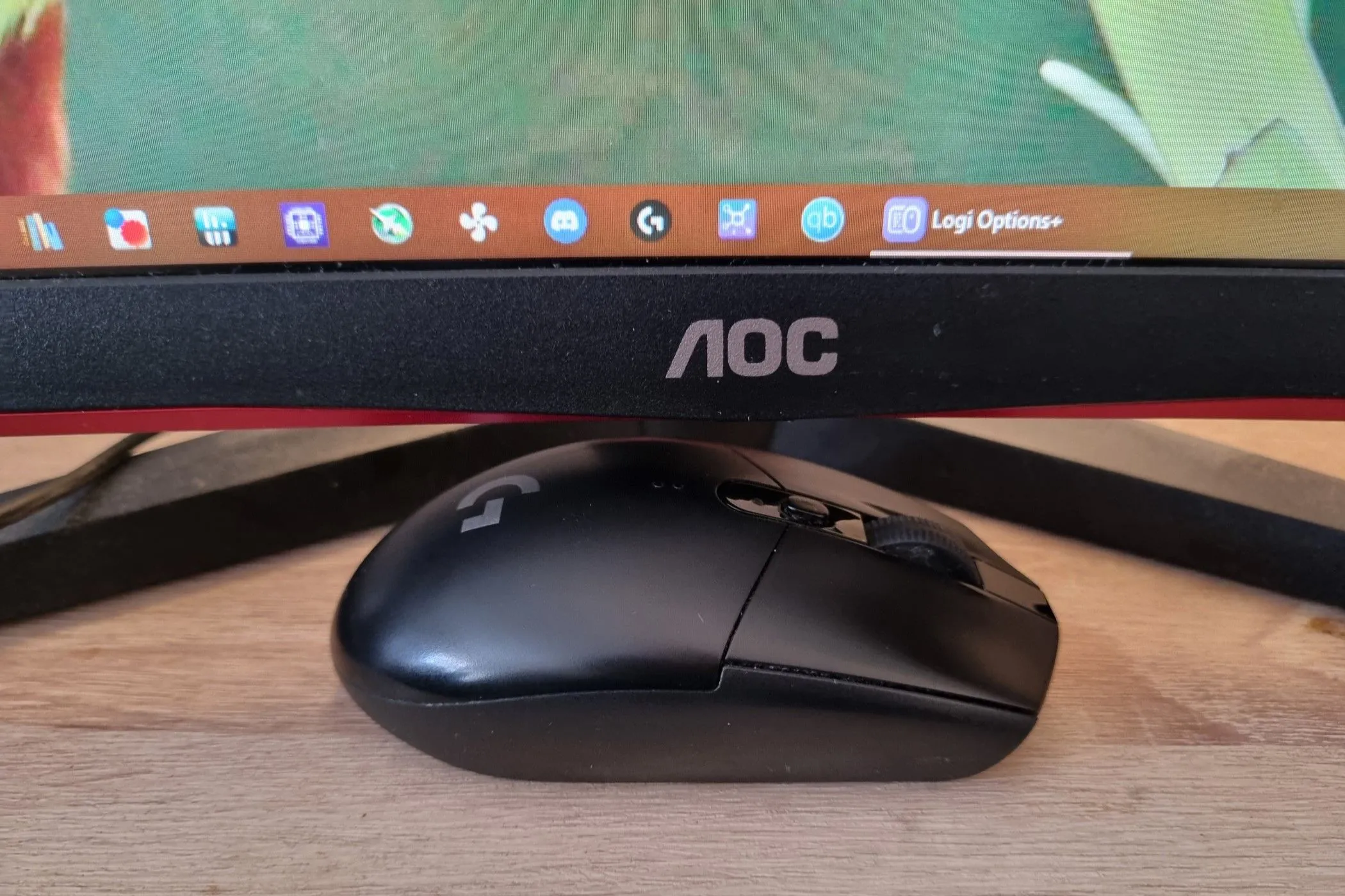 Chuột gaming không dây Logitech G305 LIGHTSPEED đặt gọn gàng dưới màn hình, thể hiện sự tiện lợi của chuột không dây