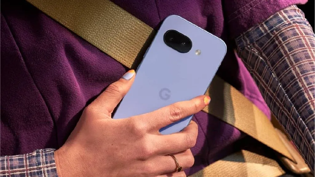 Điện thoại Google Pixel 9a màu Iris được cầm trên tay, thể hiện thiết kế và kích thước thực tế