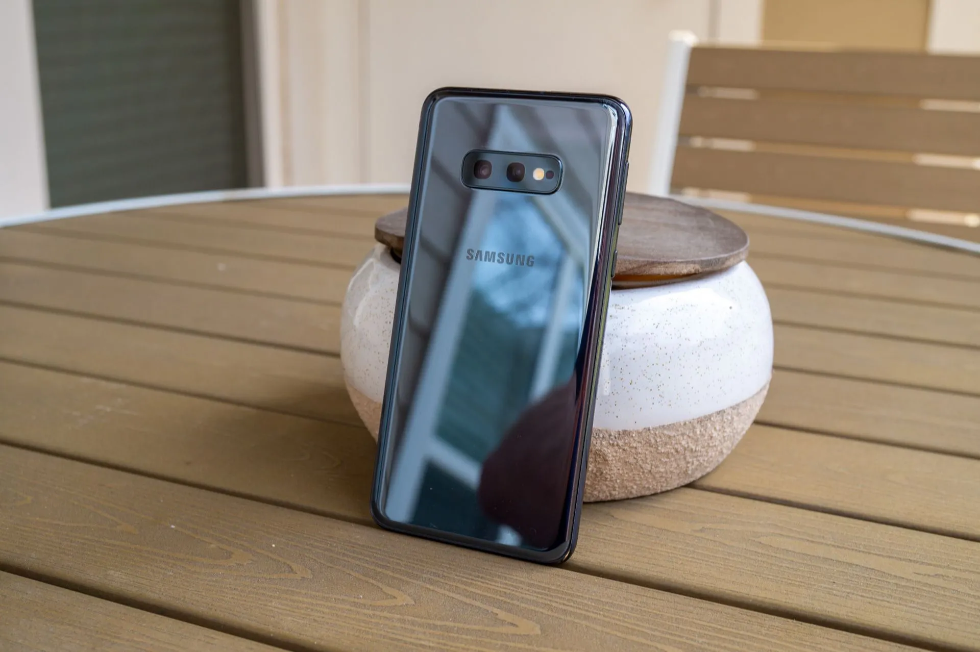 Điện thoại Samsung Galaxy S10e màu trắng đặt trên bàn, cho thấy thiết kế nhỏ gọn, màn hình tràn viền và cảm biến vân tay tích hợp cạnh bên, một flagship compact ấn tượng.