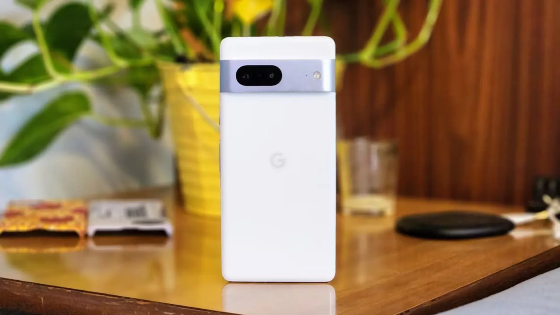 Google Pixel 7 màu trắng đứng trên bàn, nổi bật cụm camera ngang đặc trưng và mặt lưng kính