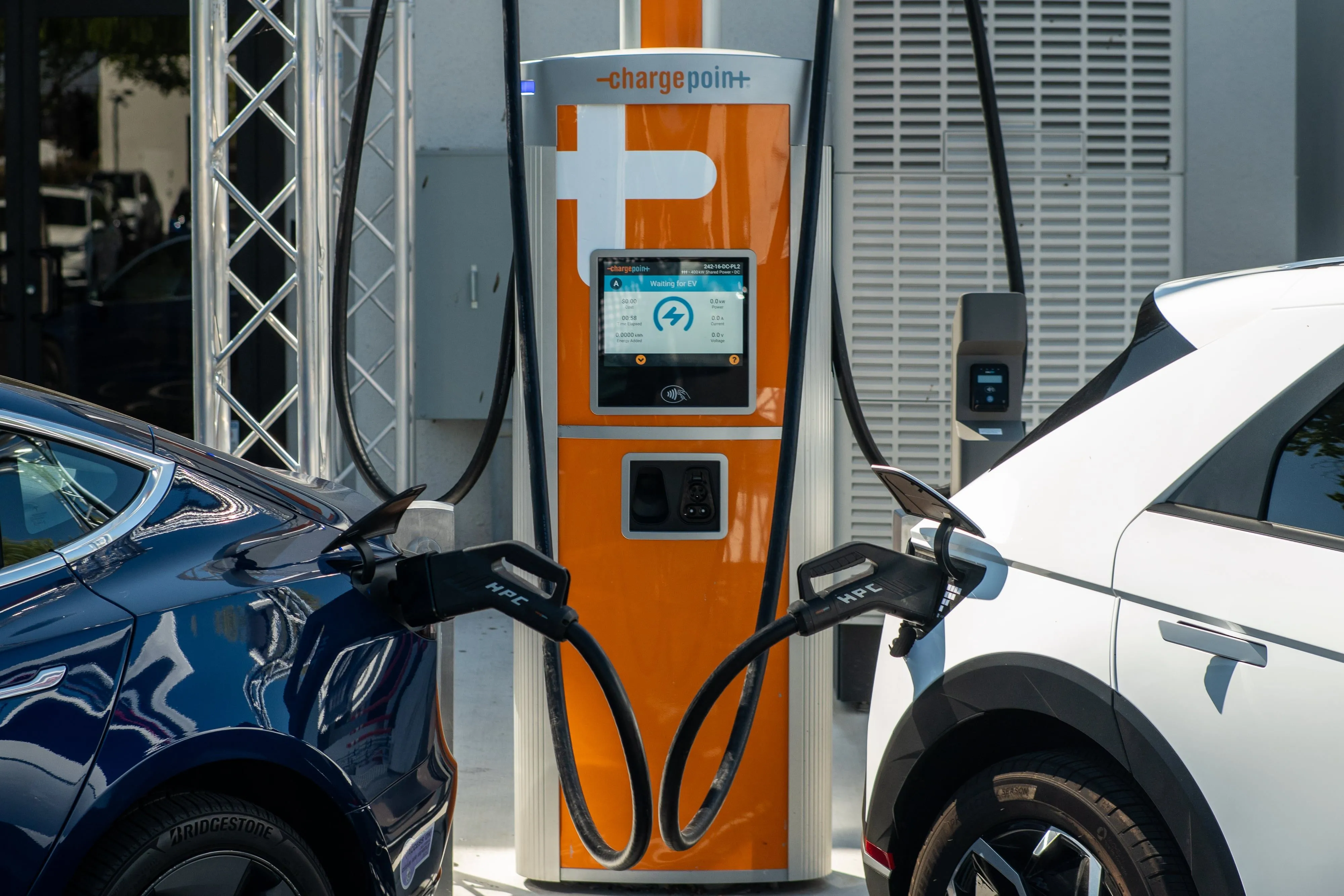 Hai xe điện đang sạc tại trạm sạc ChargePoint, minh họa sự phụ thuộc vào ứng dụng smartphone để sử dụng dịch vụ.