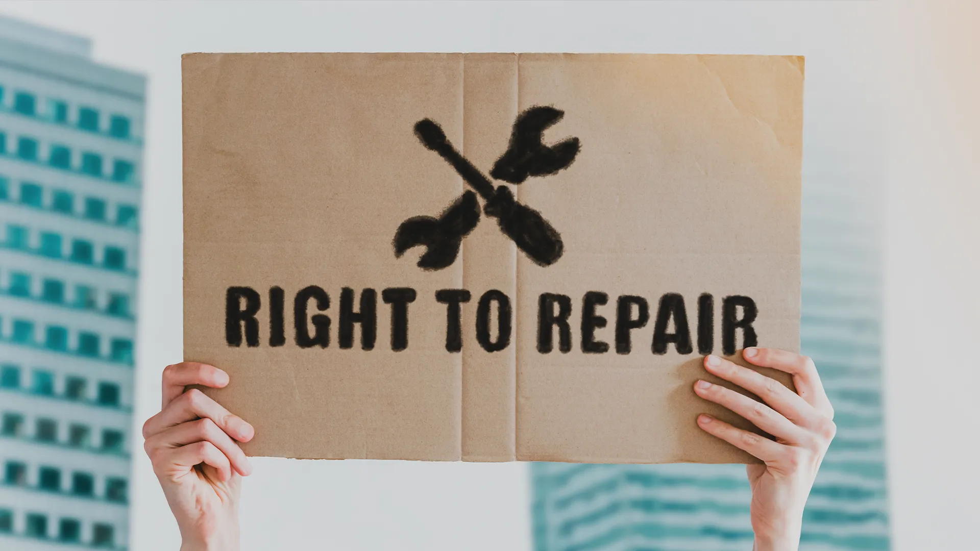Hình ảnh bàn tay cầm bảng có chữ &quot;Right to Repair&quot; (Quyền được sửa chữa), biểu tượng của phong trào.