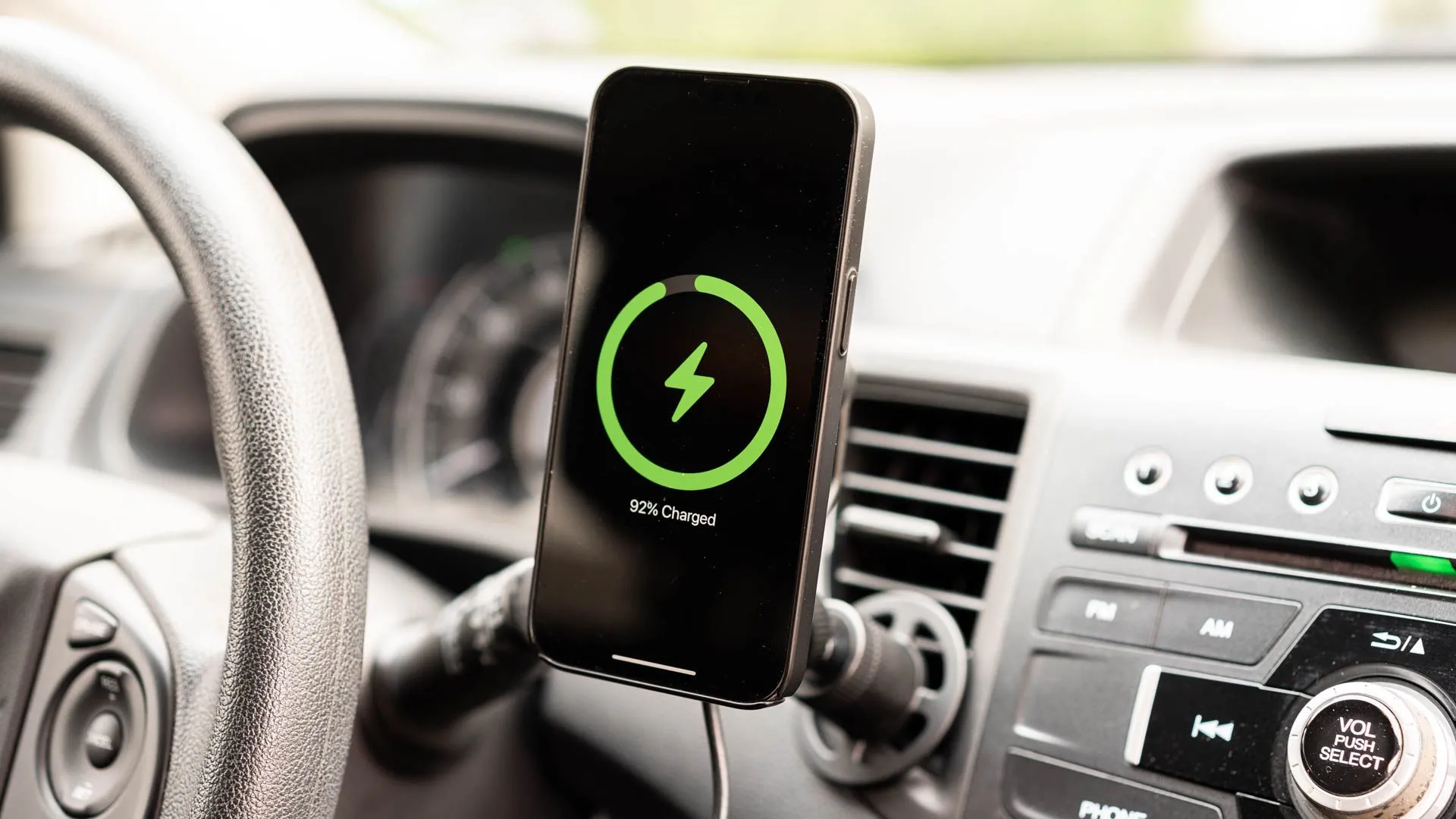 iPhone đang sạc trên giá đỡ sạc không dây mophie Wireless Charging Vent Mount với MagSafe, mang lại sự tiện lợi và an toàn khi lái xe