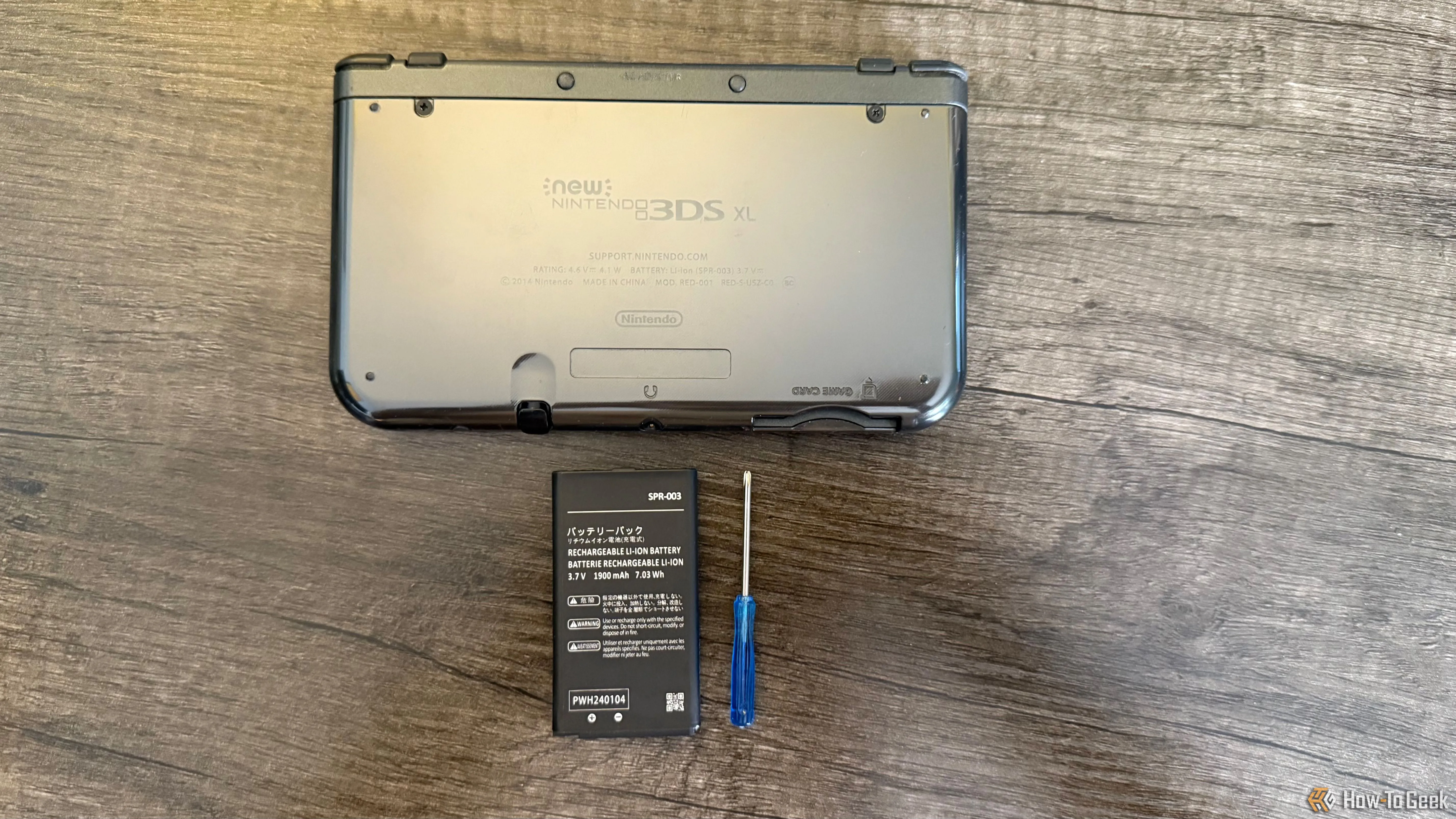 Mặt sau của New Nintendo 3DS XL với pin thay thế và tua vít