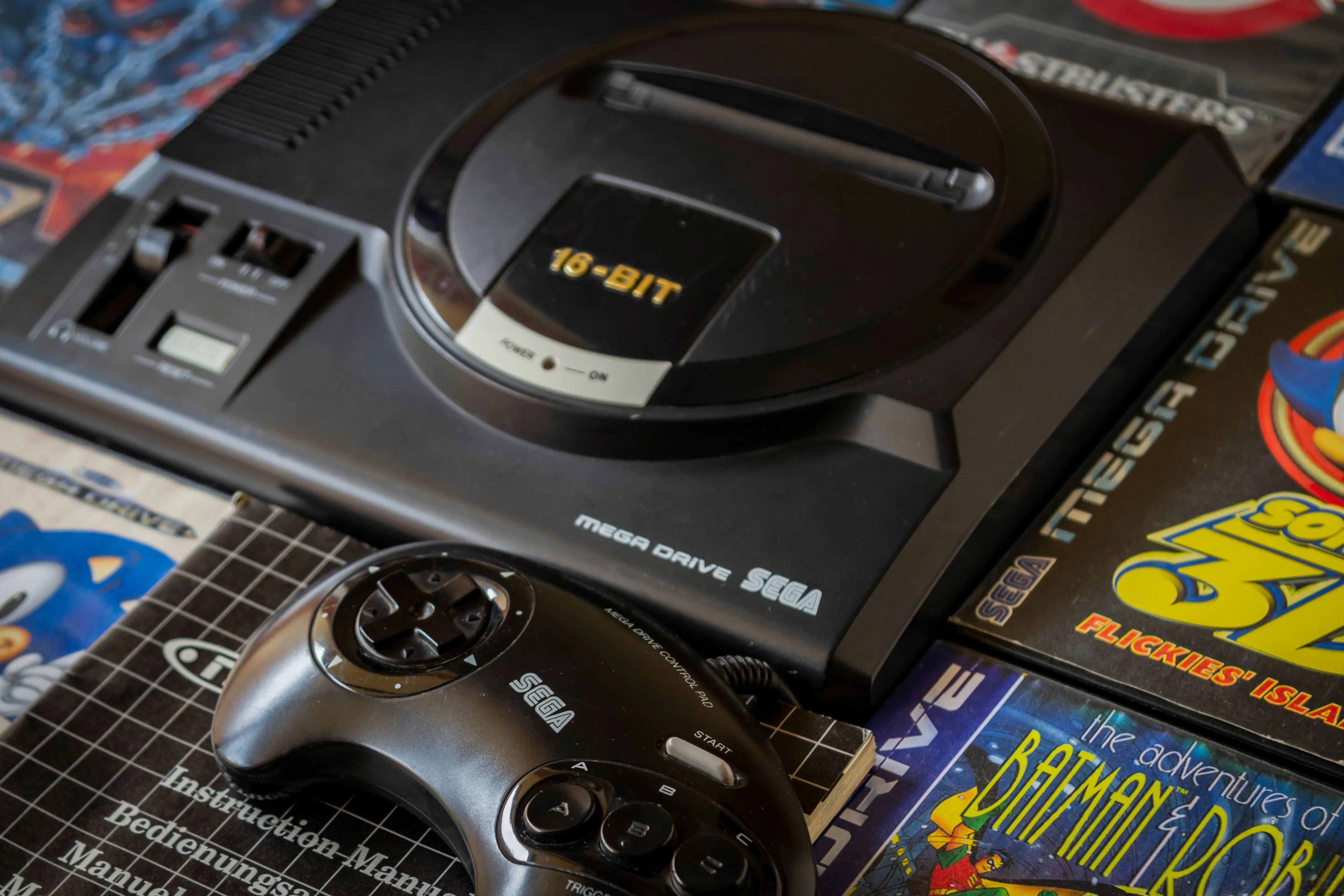 Máy chơi game Sega Genesis cùng băng game và tay cầm điều khiển, biểu tượng của cuộc chiến console và tính năng Blast Processing