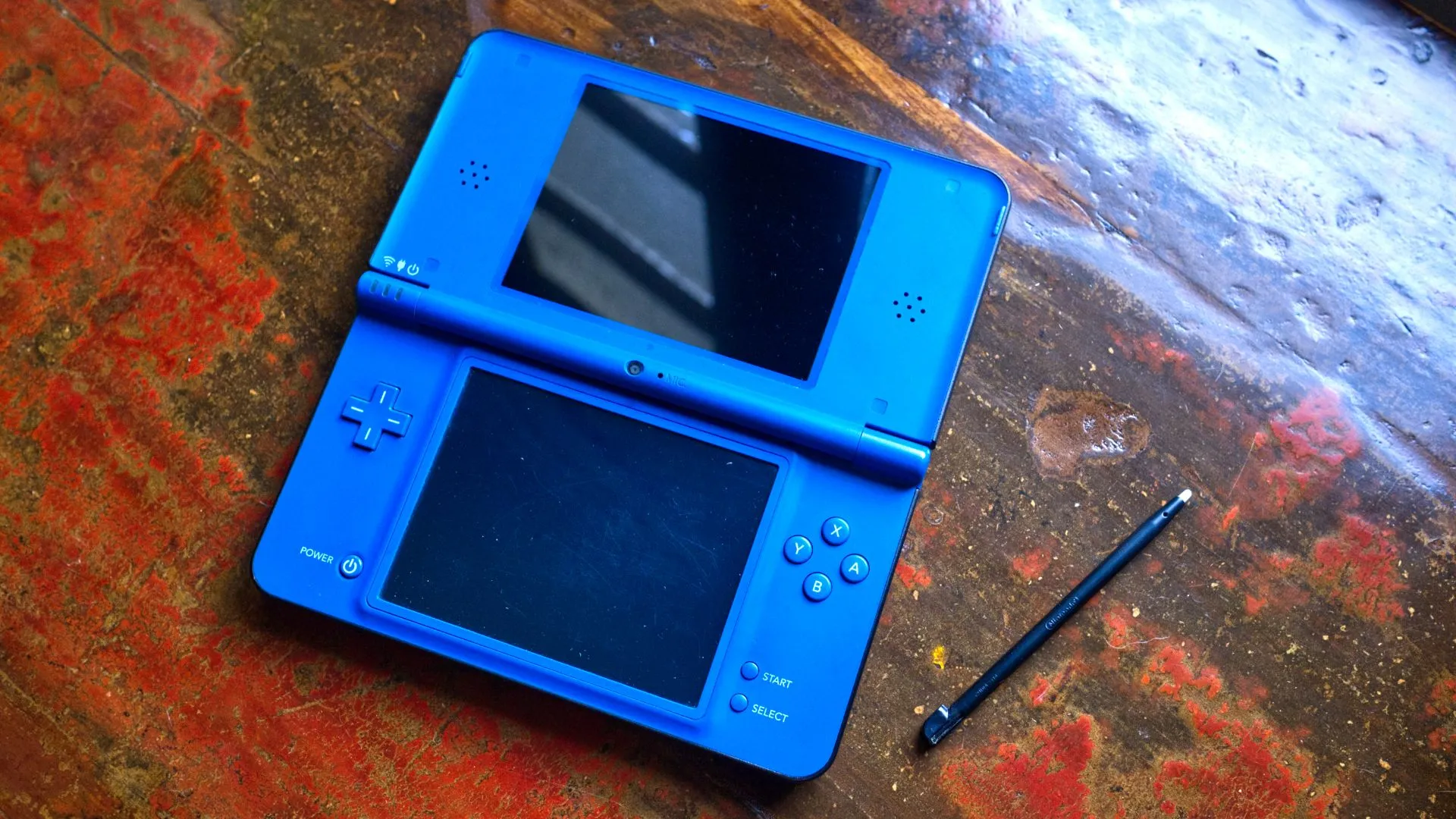 Máy Nintendo DSi XL màu xanh đang mở với bút stylus