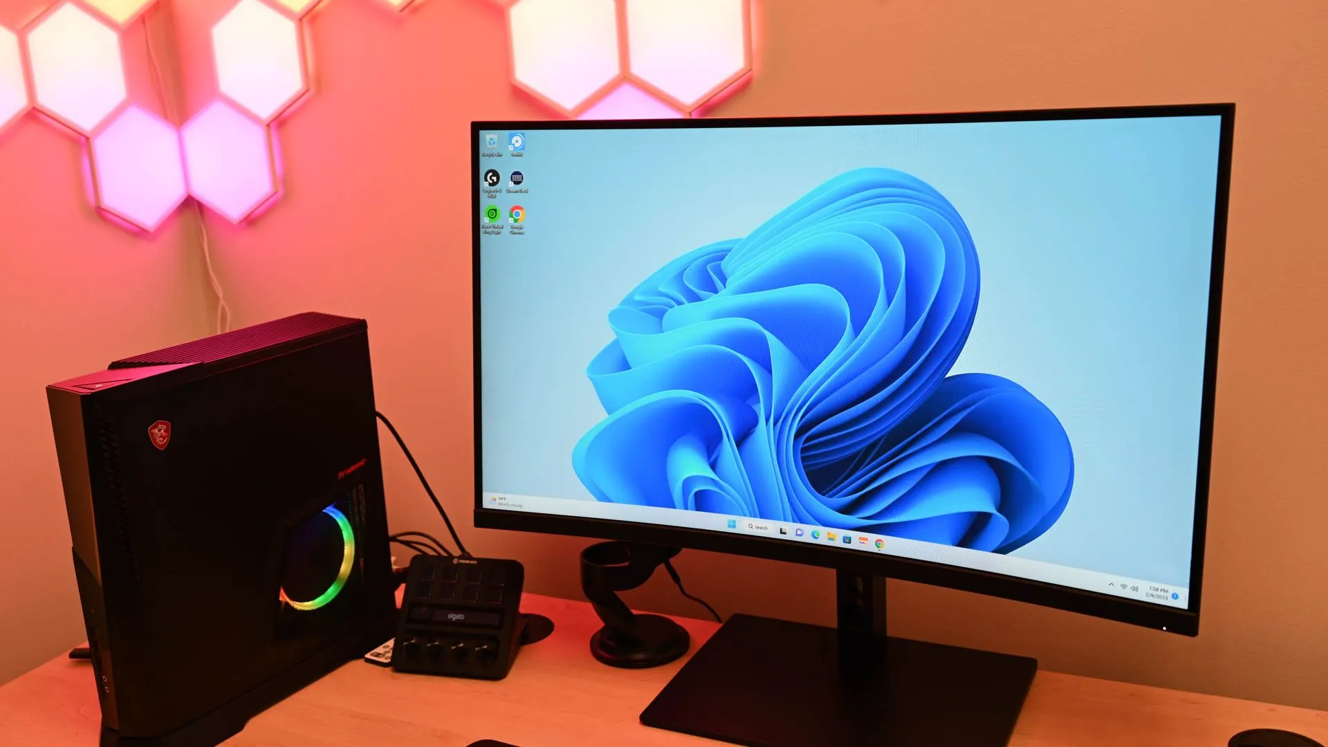 Máy tính chạy Windows 11 được đặt trên bàn làm việc gần loa, minh họa trải nghiệm chậm chạp và ì ạch so với Linux.