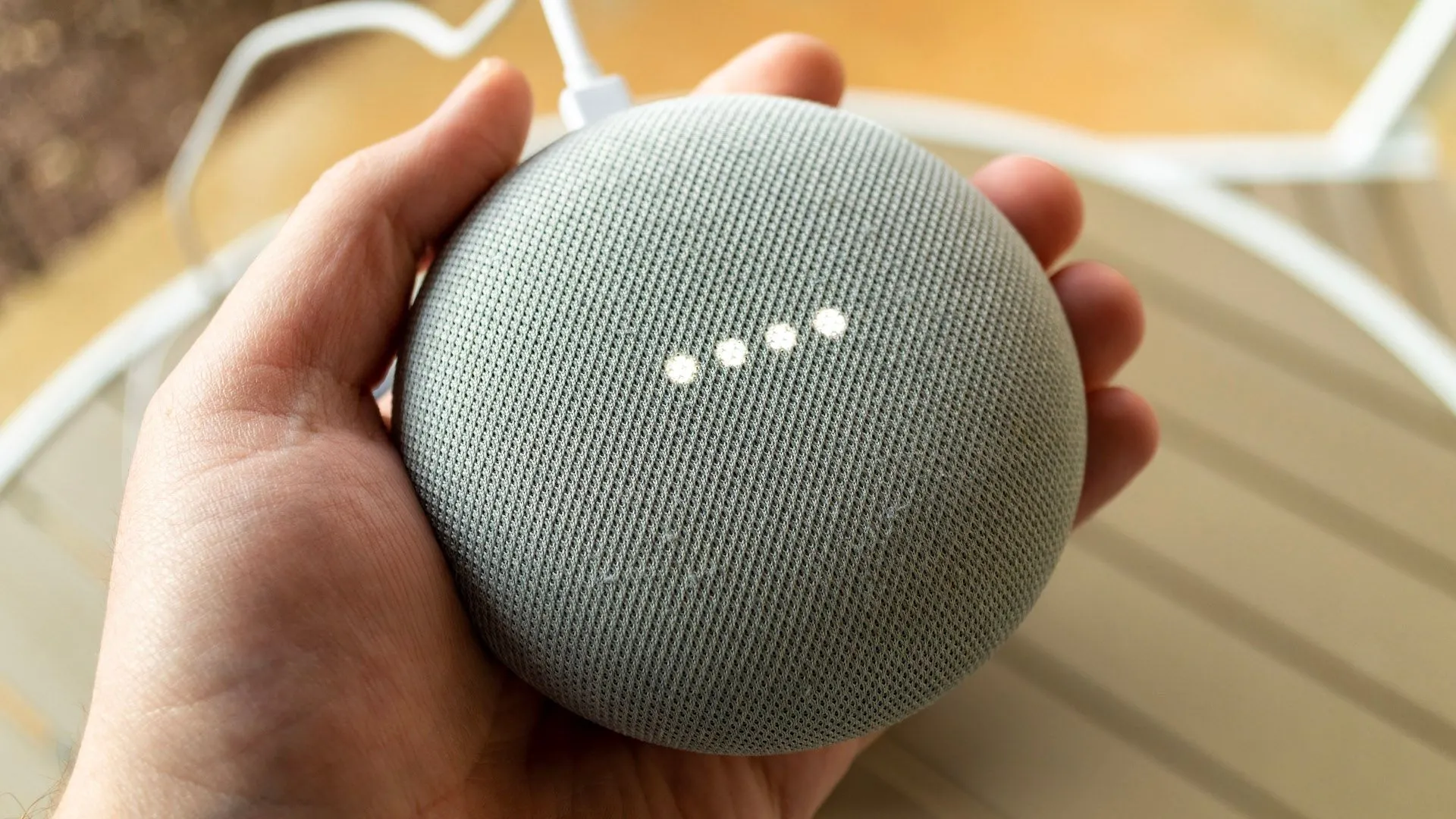 Một bàn tay đang cầm loa Google Nest
