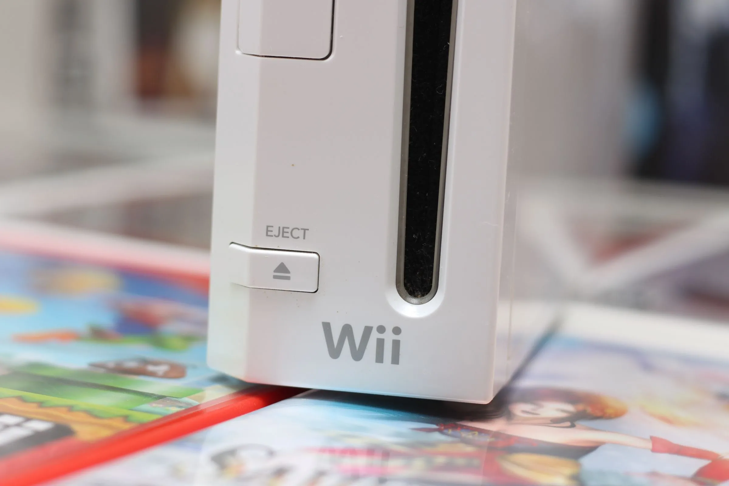 Một chiếc máy chơi game Nintendo Wii màu trắng đặt trên bề mặt