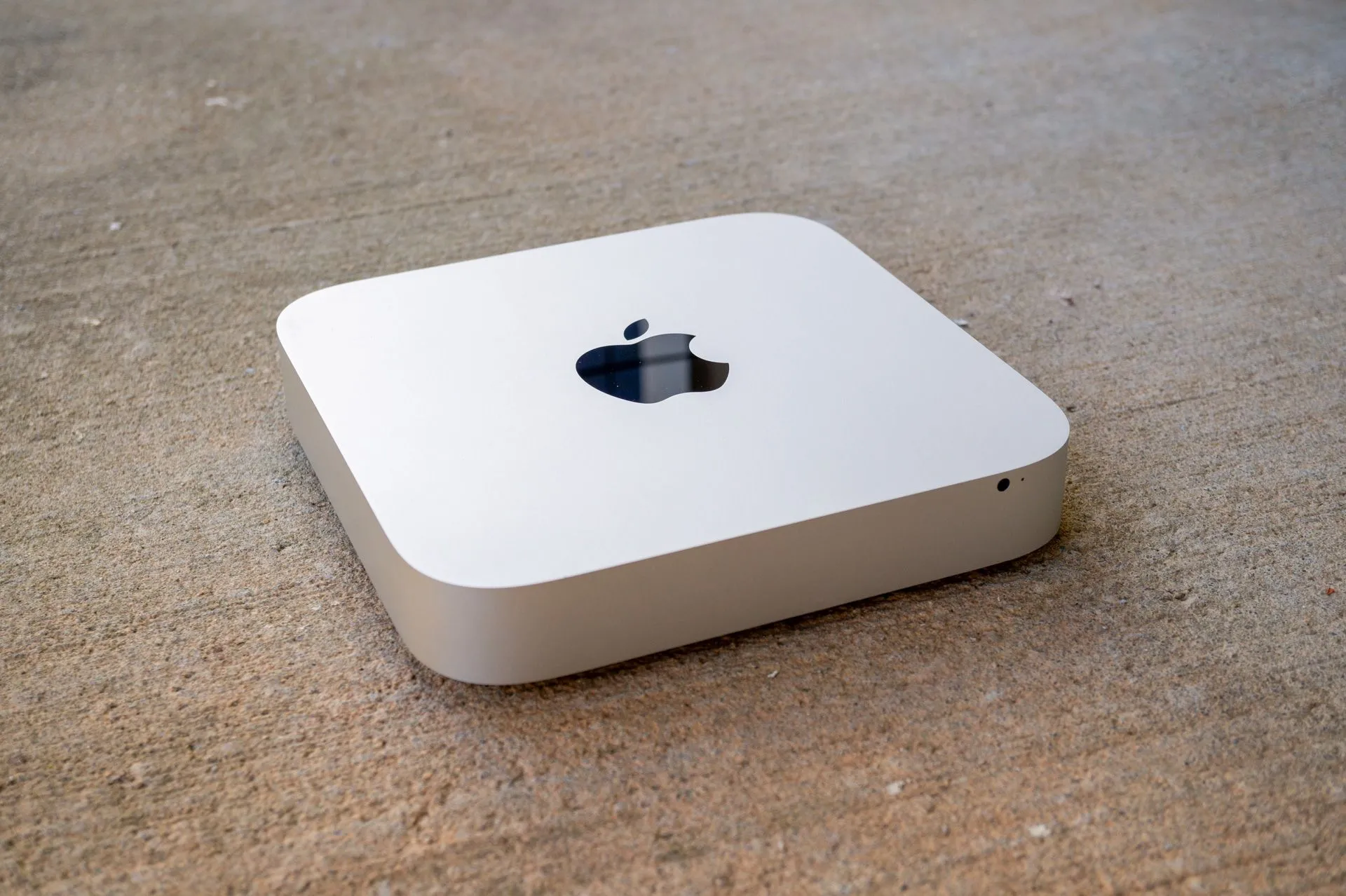 Một chiếc máy tính Mac mini trên bề mặt bê tông.