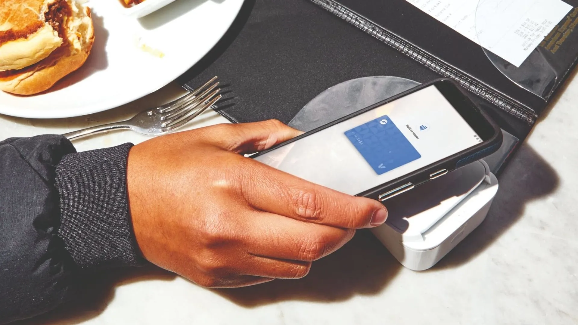 Một khách hàng thực hiện thanh toán không tiếp xúc bằng Google Wallet tại máy POS chuyên dụng