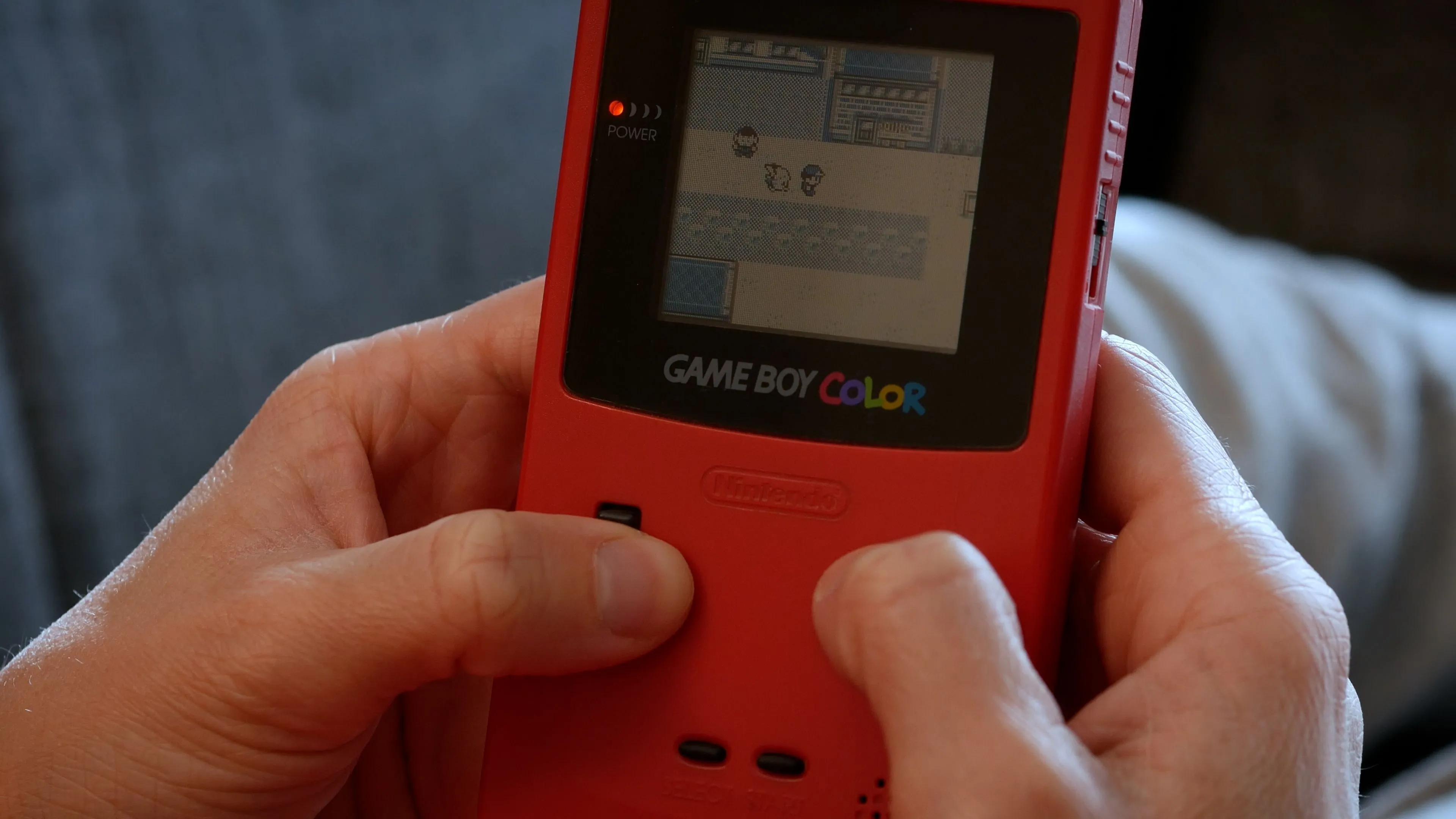Một người chơi game Pokémon trên Game Boy Color, gợi nhớ kỷ niệm về dòng game nhập vai huyền thoại này.