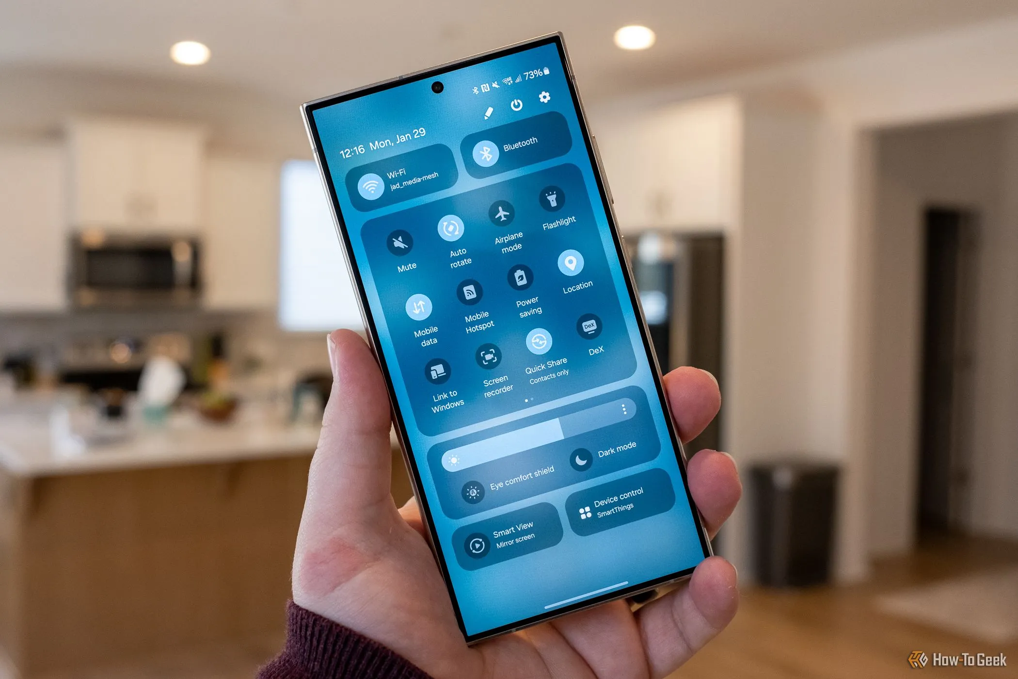 Một người đang cầm điện thoại Samsung Galaxy S24 Ultra, màn hình hiển thị menu cài đặt nhanh.