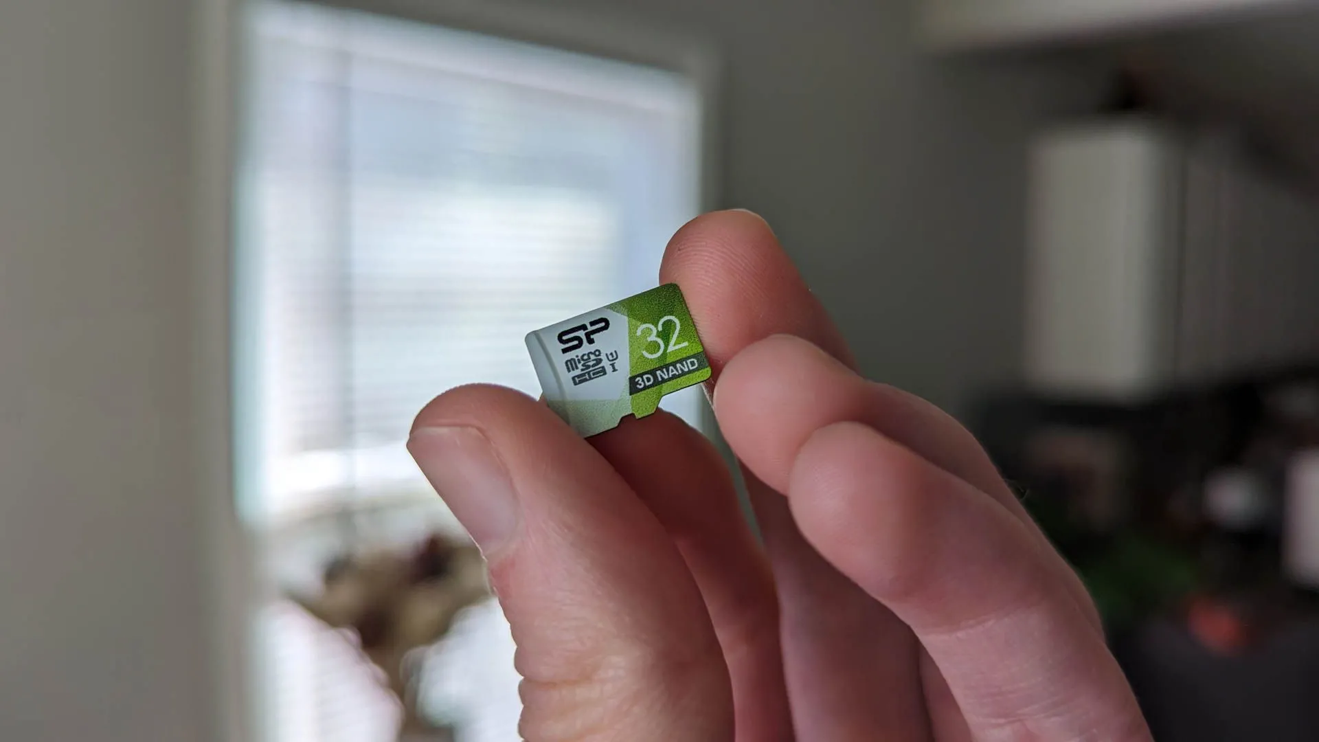 Một người đang cầm thẻ nhớ Micro SD dung lượng cao, phụ kiện cần thiết để mở rộng bộ nhớ Steam Deck