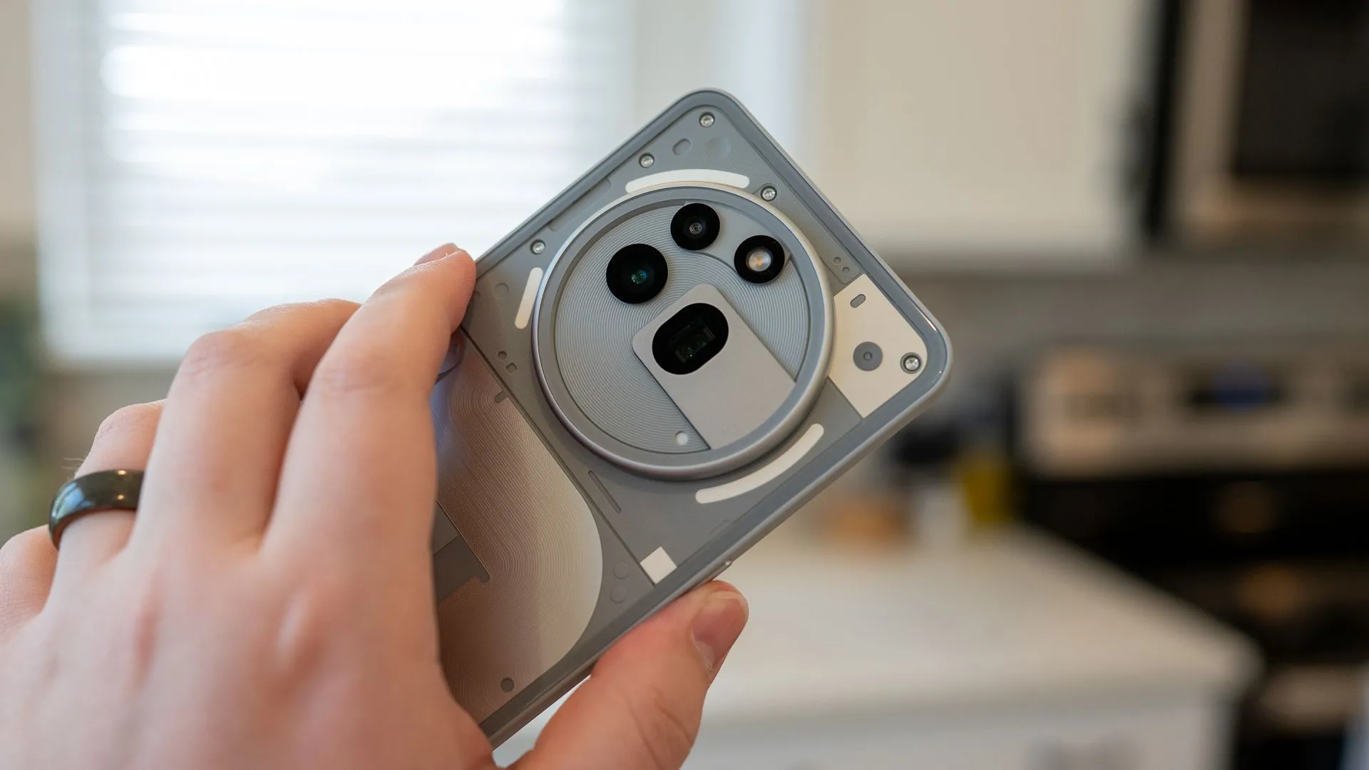 Người dùng cầm Nothing Phone (3a) Pro, tập trung vào thiết kế độc đáo và cụm camera sau.