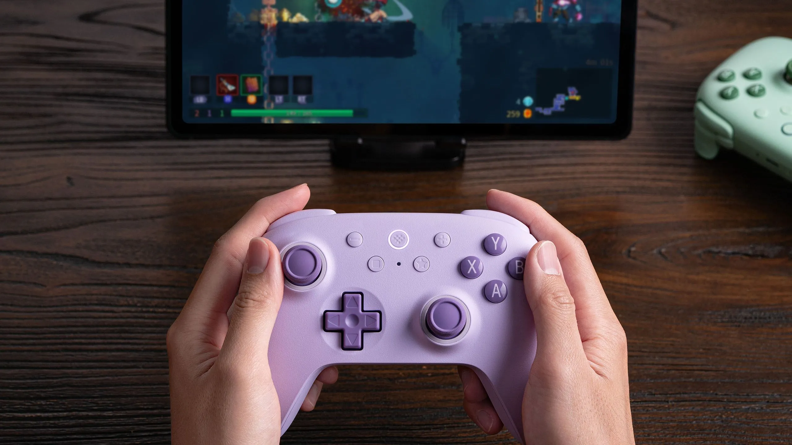 Người dùng chơi game Dead Cells trên máy tính bảng với tay cầm 8BitDo Ultimate 2C Wireless